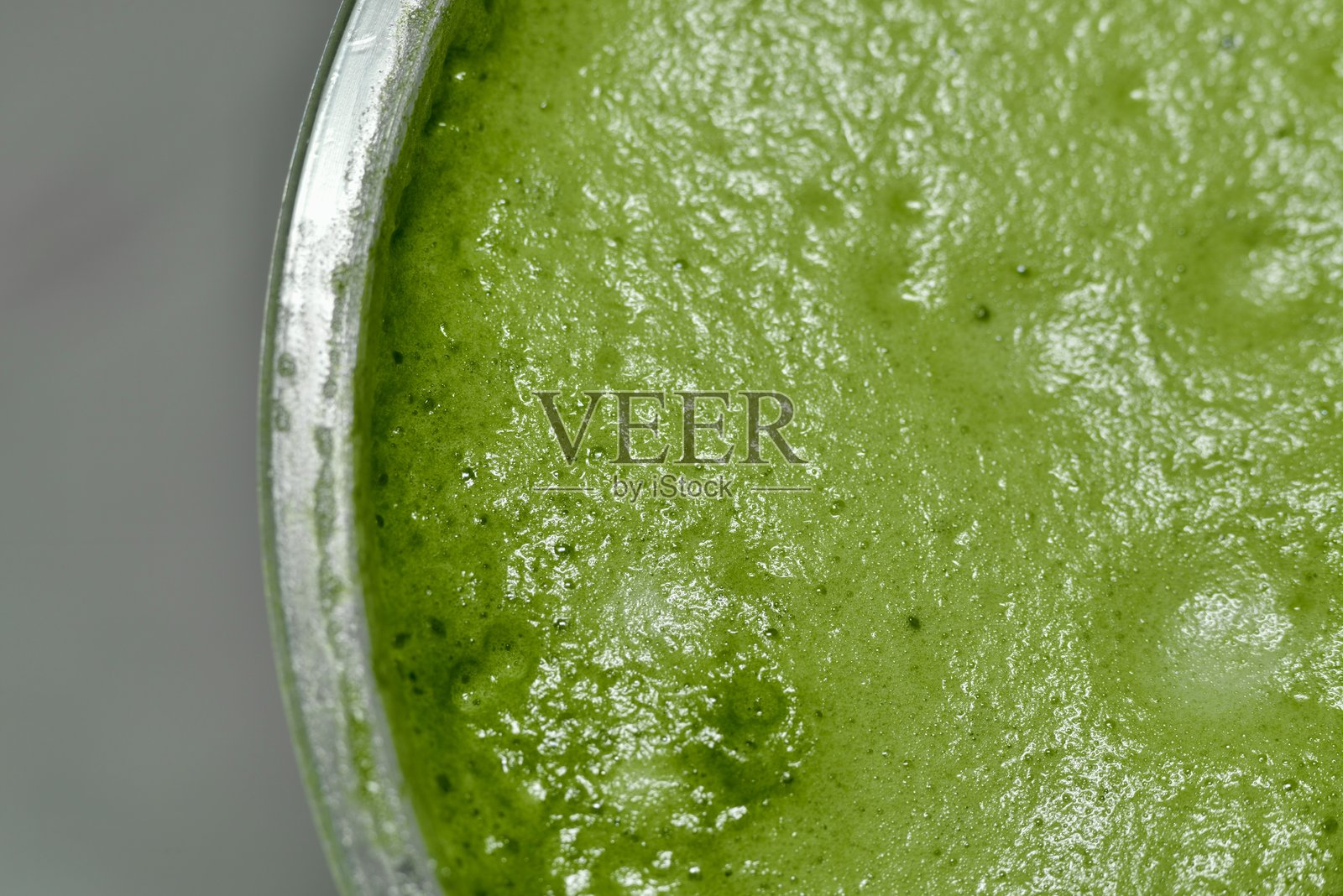 特写镜头捕捉绿茶细腻的特征，展现光滑、泡沫丰富的质感。鲜艳的绿色和表面可见的气泡突显了抹茶的新鲜度和品质。照片摄影图片