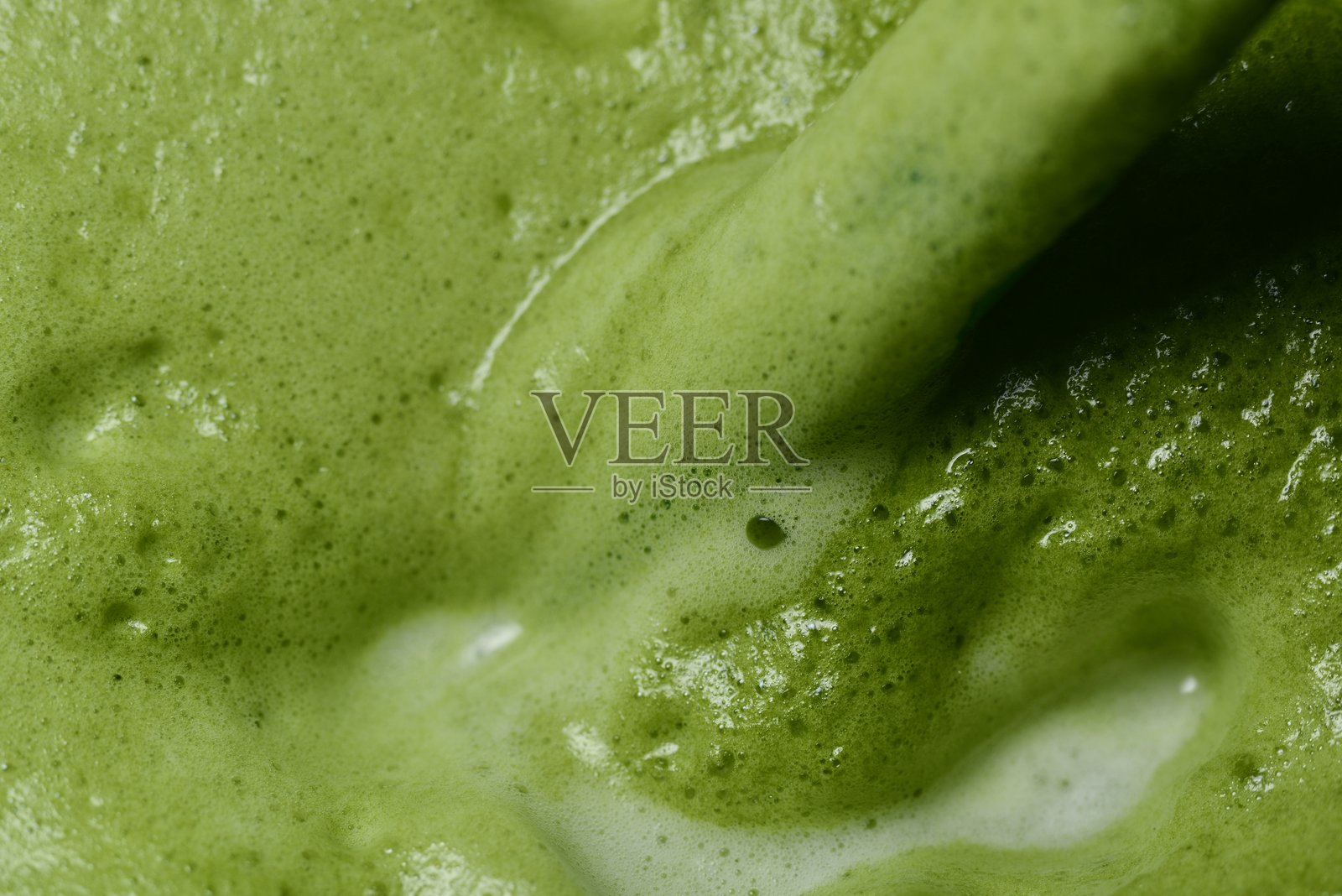 一张新鲜制作的绿茶特写图，突出光滑、泡沫丰富的表面，能看到明显的气泡。照片摄影图片