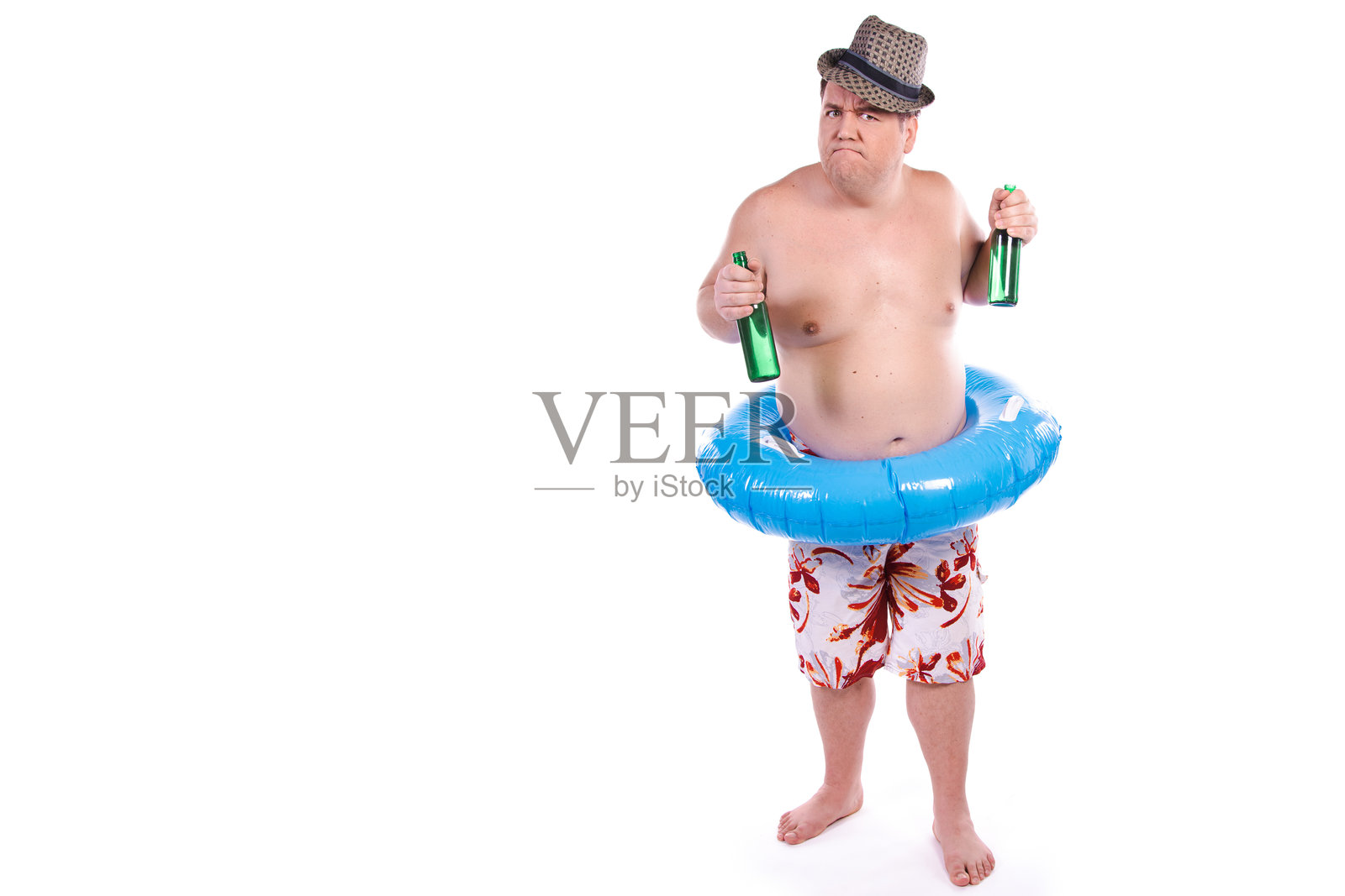 夏天、假期和海洋。一个搞笑的胖子正拿着充气圈跳舞。照片摄影图片