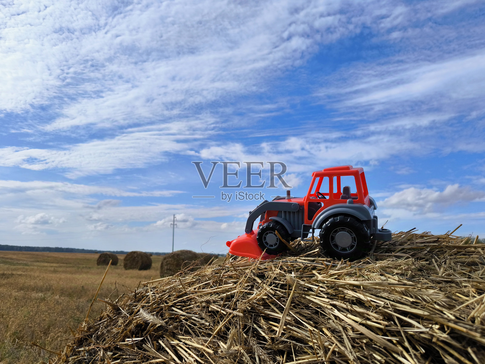 田野里有一辆红色拖拉机照片摄影图片
