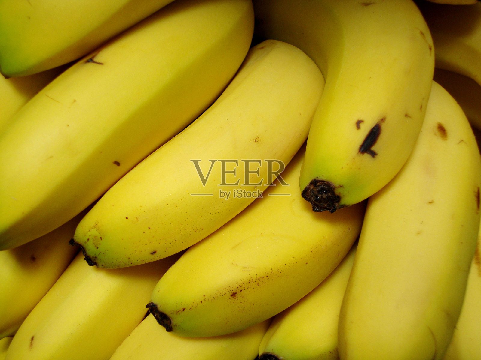 新鲜的黄色香蕉在超市展示架上堆放在一起，展现出它们的成熟度和鲜艳的颜色照片摄影图片