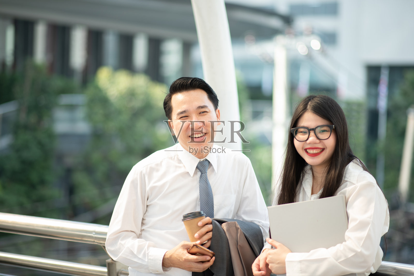 微笑的同事们在城市中站立照片摄影图片