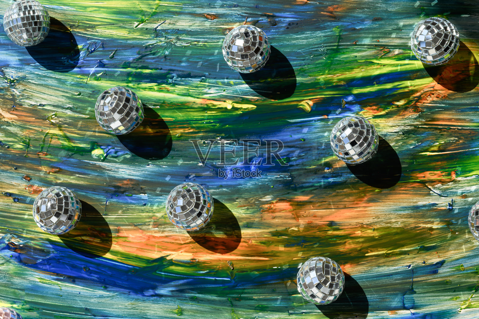 五光十色的油漆背景上的迪斯科球图案。照片摄影图片