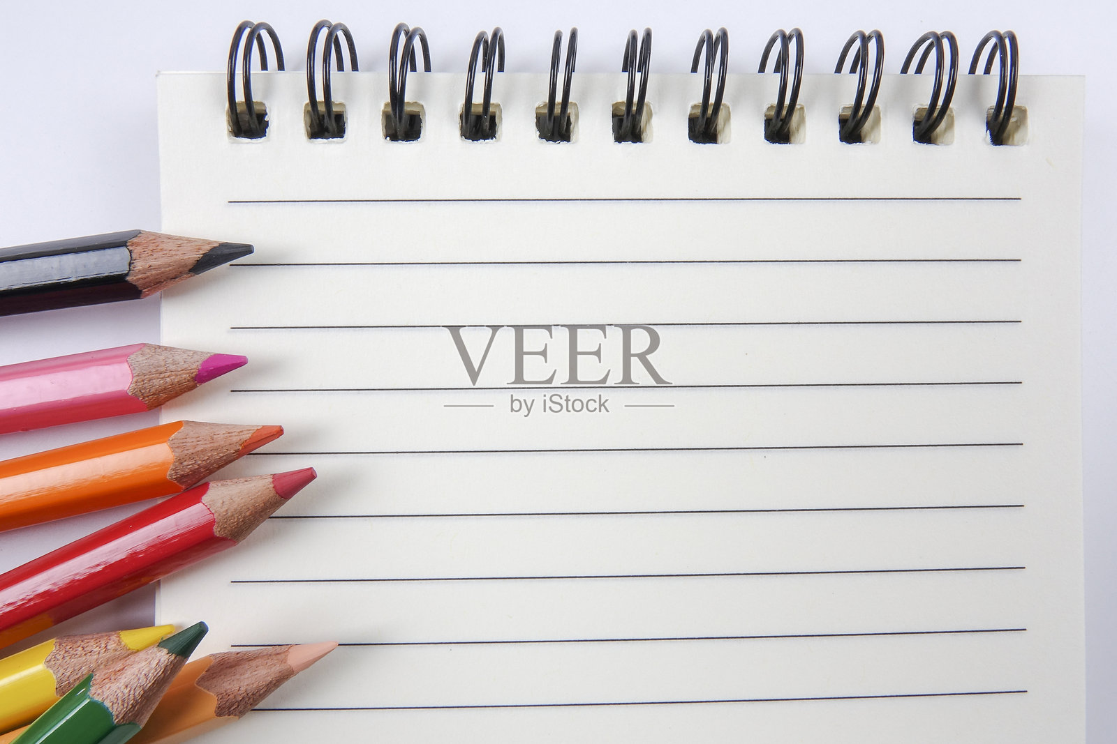 从上方拍摄的五彩铅笔与桌上的笔记本照片摄影图片