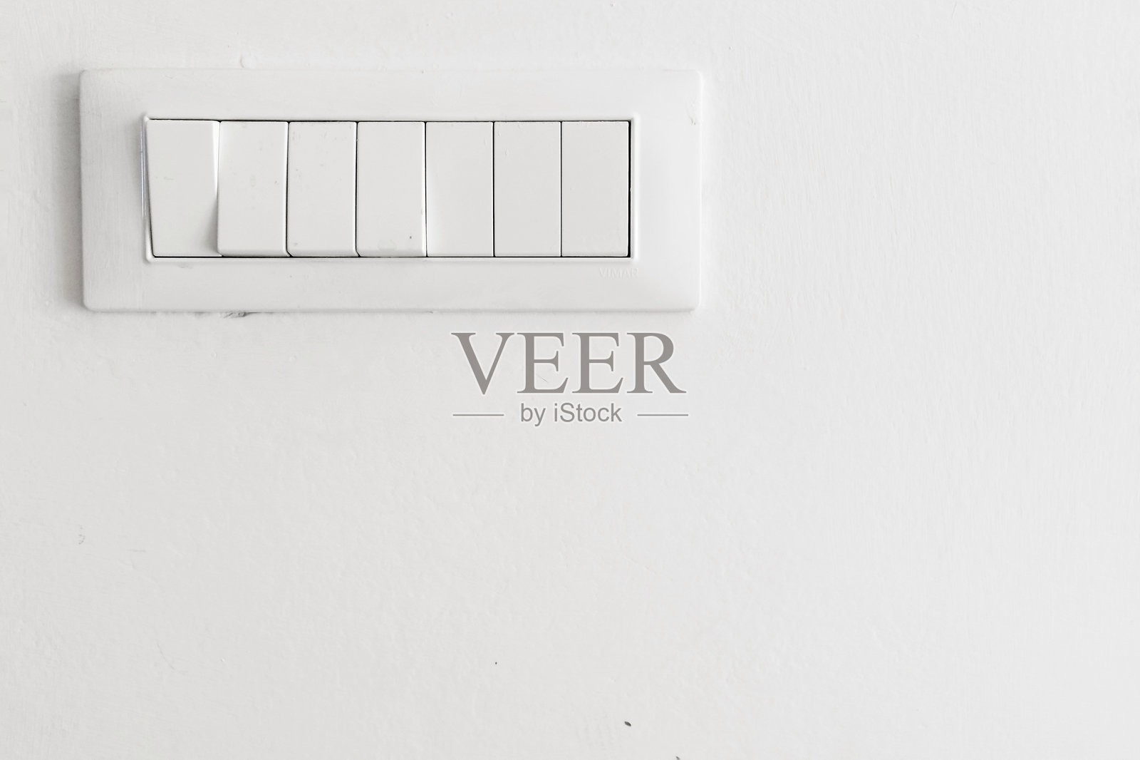 白墙上的灯开关特写照片摄影图片