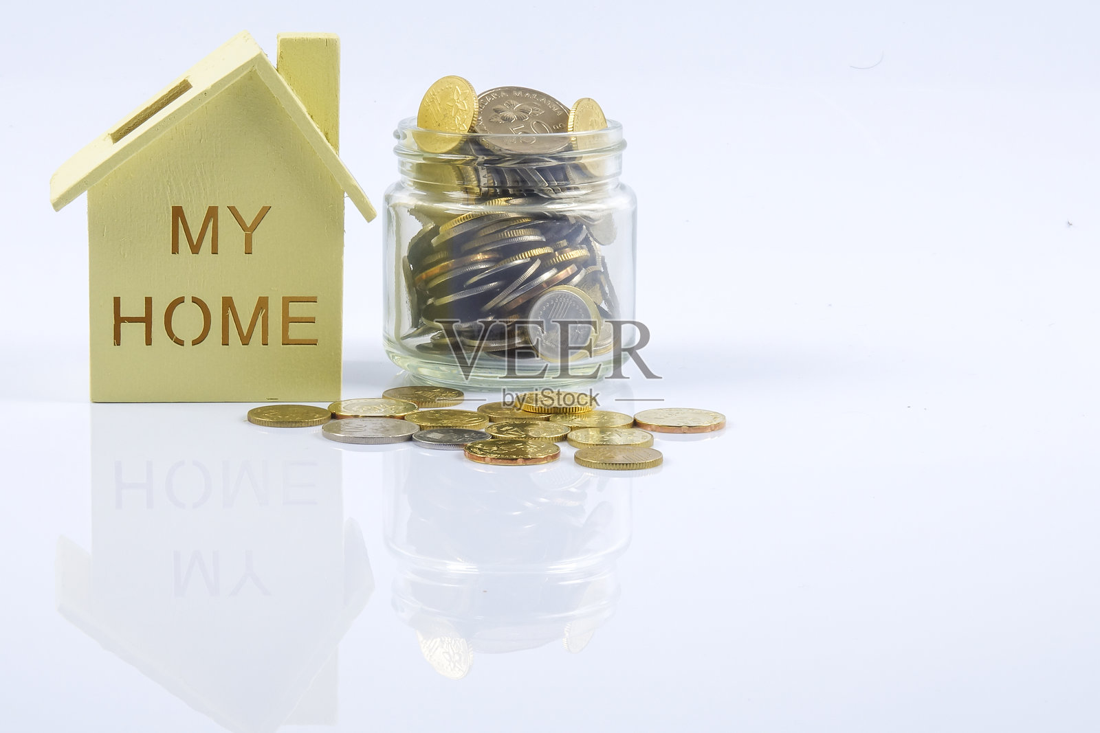 白色背景下的硬币和模型房屋特写照片摄影图片