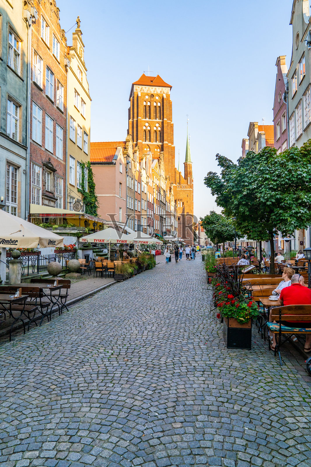 鹅卵石街道与户外用餐区，背景是圣玛丽教堂塔楼。照片摄影图片