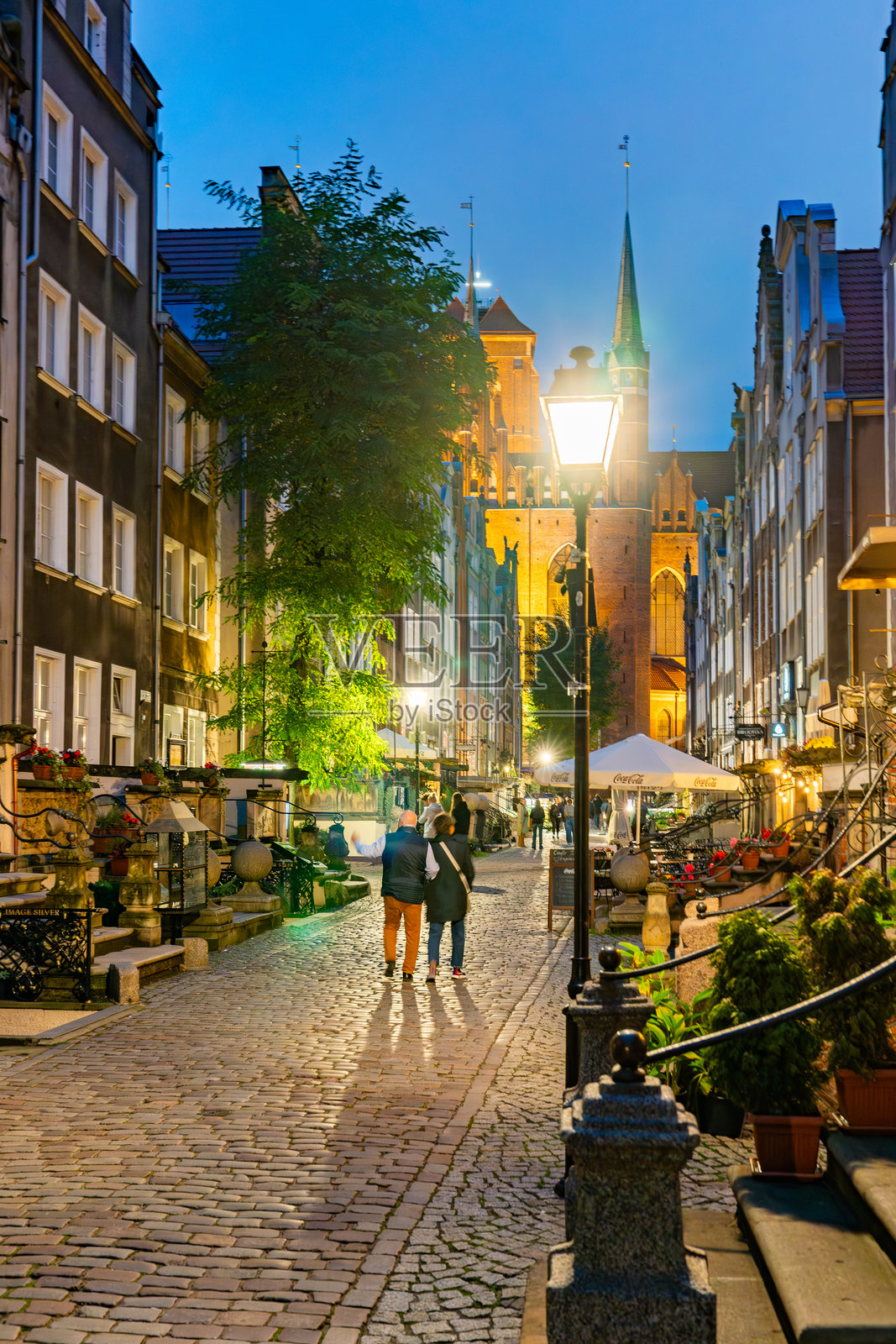 黄昏时分的历史悠久的格但斯克玛利亚卡街,传统建筑和户外座位区。照片摄影图片