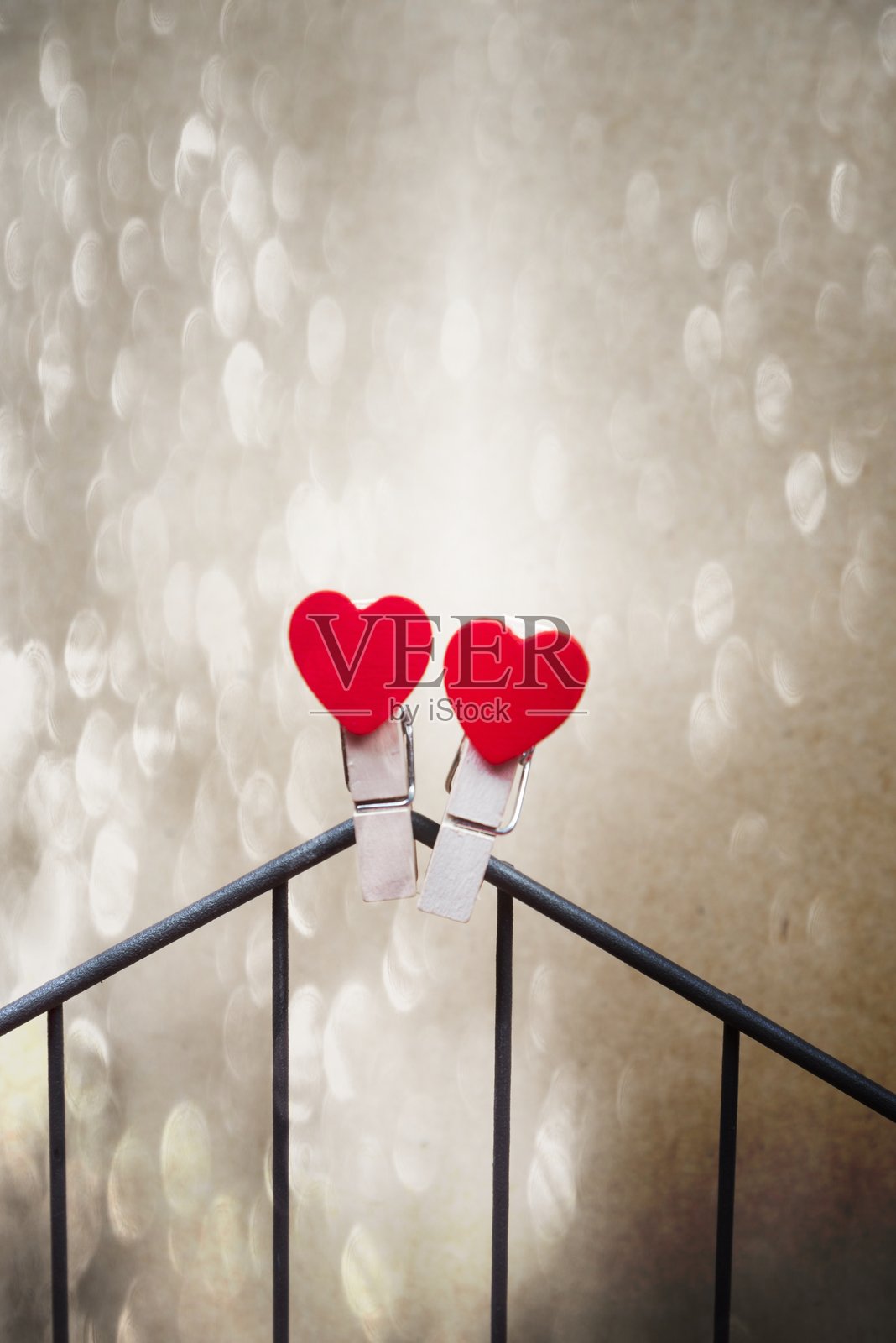 红色心形夹子的特写，放在栏杆上照片摄影图片