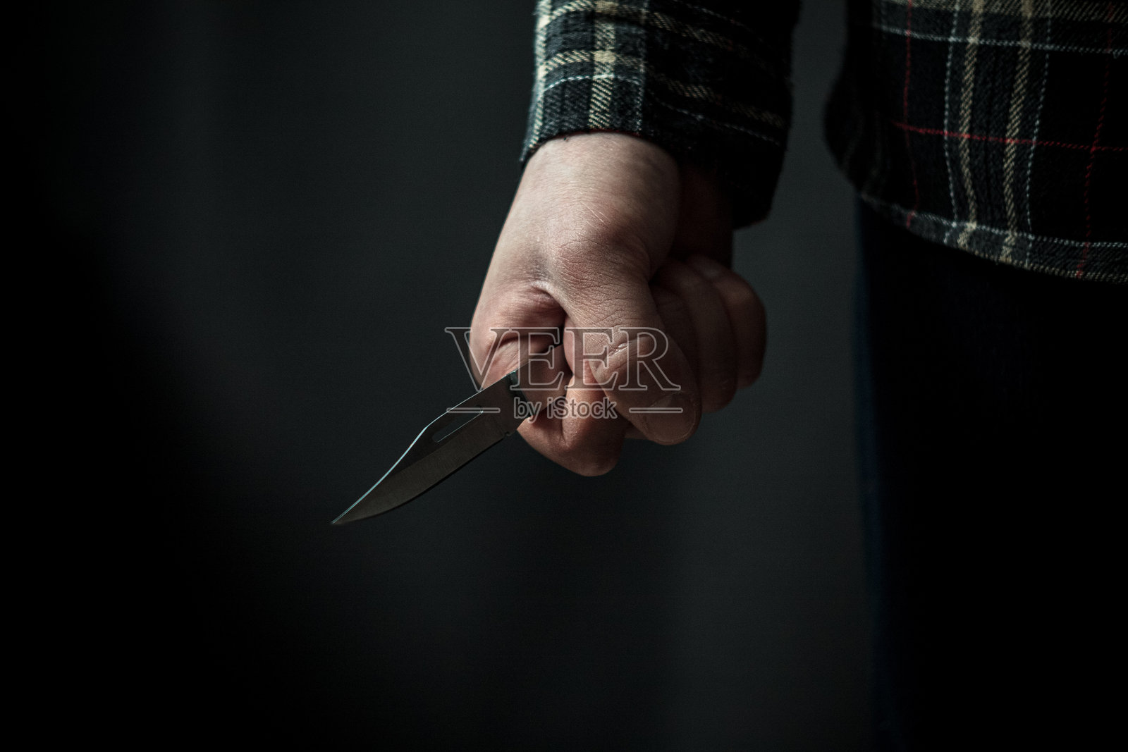 男子手持刀具，是犯罪紧张时刻的化身照片摄影图片