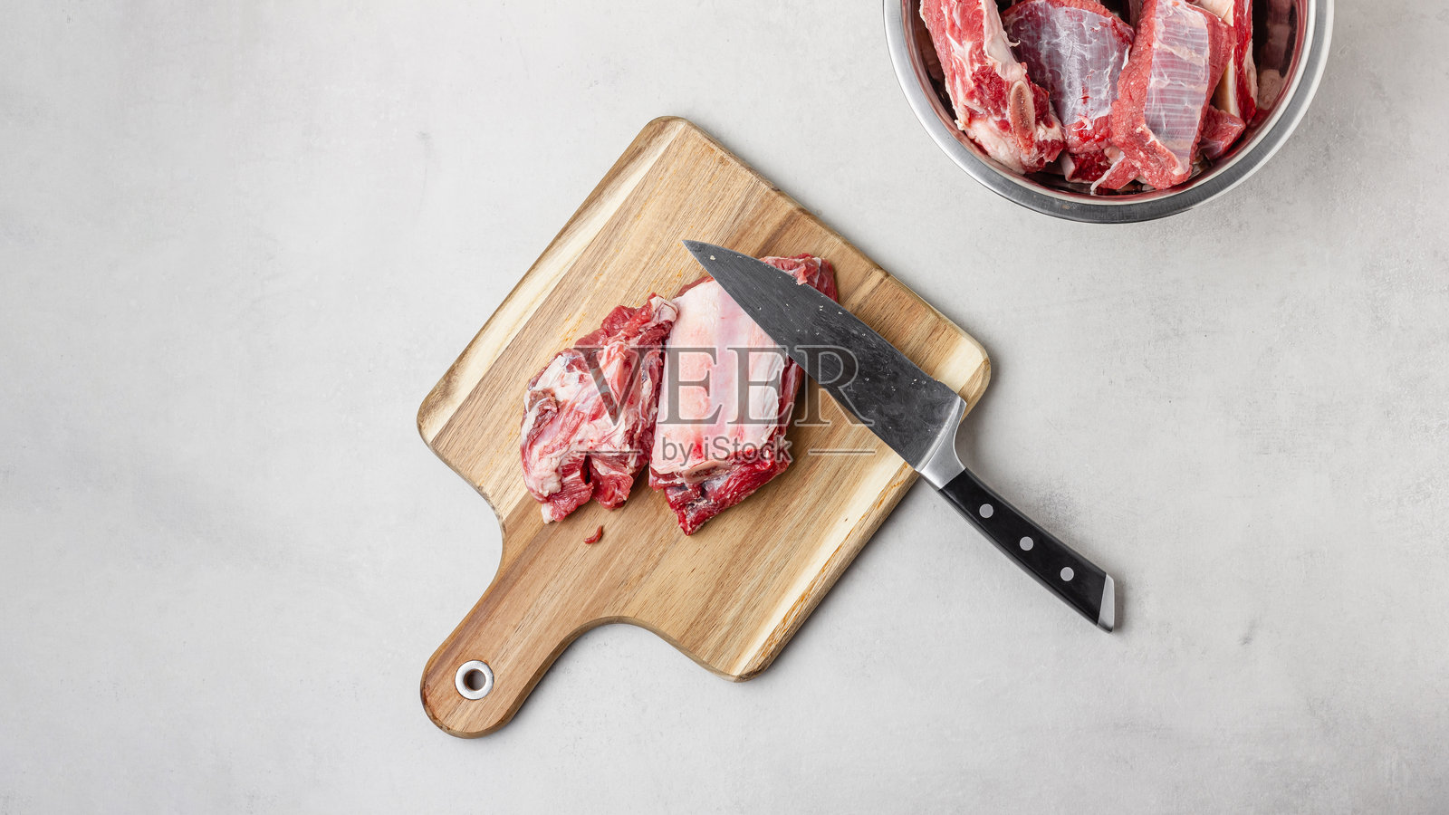 木砧板上的生牛肋骨与刀照片摄影图片