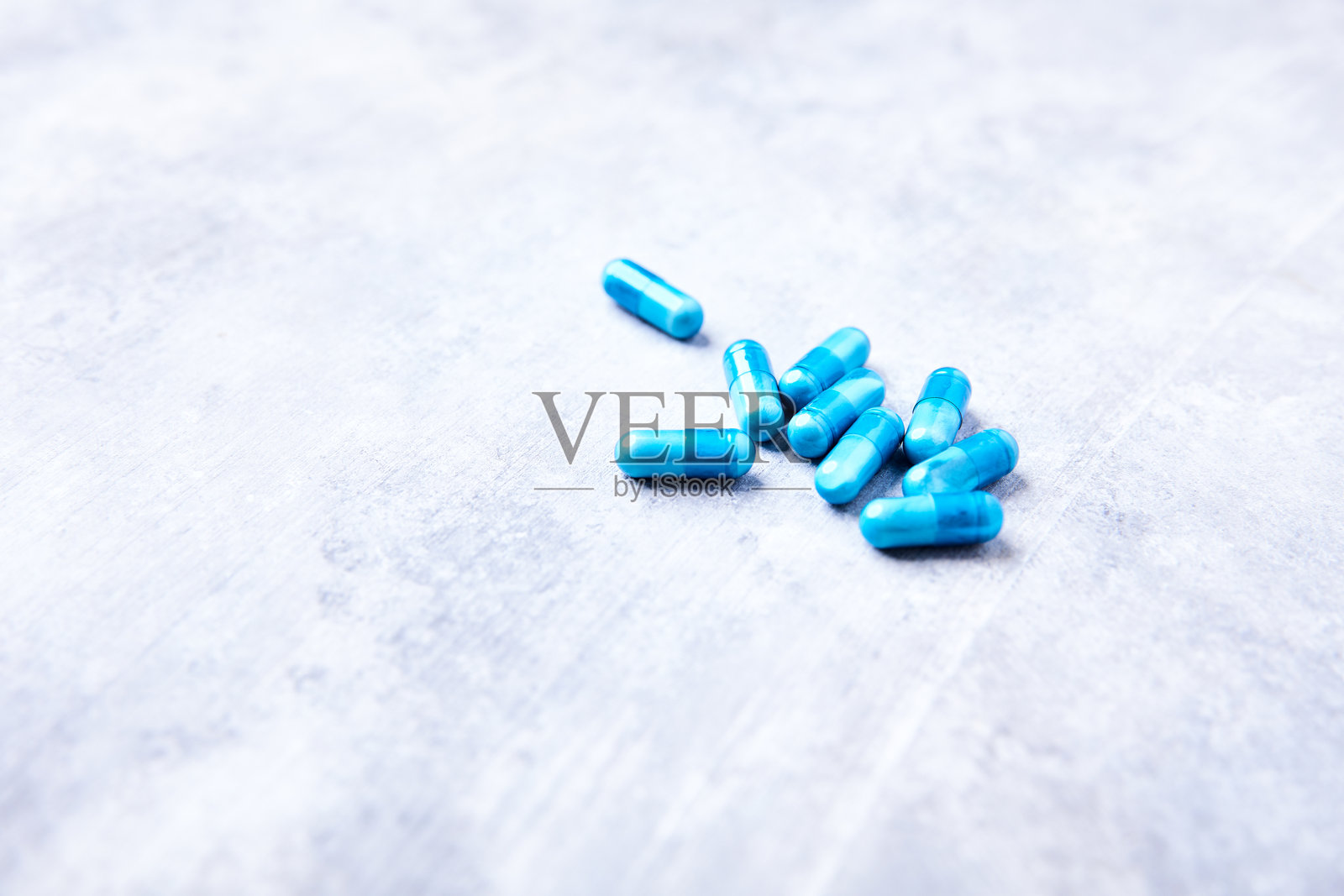 明亮石材背景上的氨基酸胶囊，柔焦特写照片摄影图片