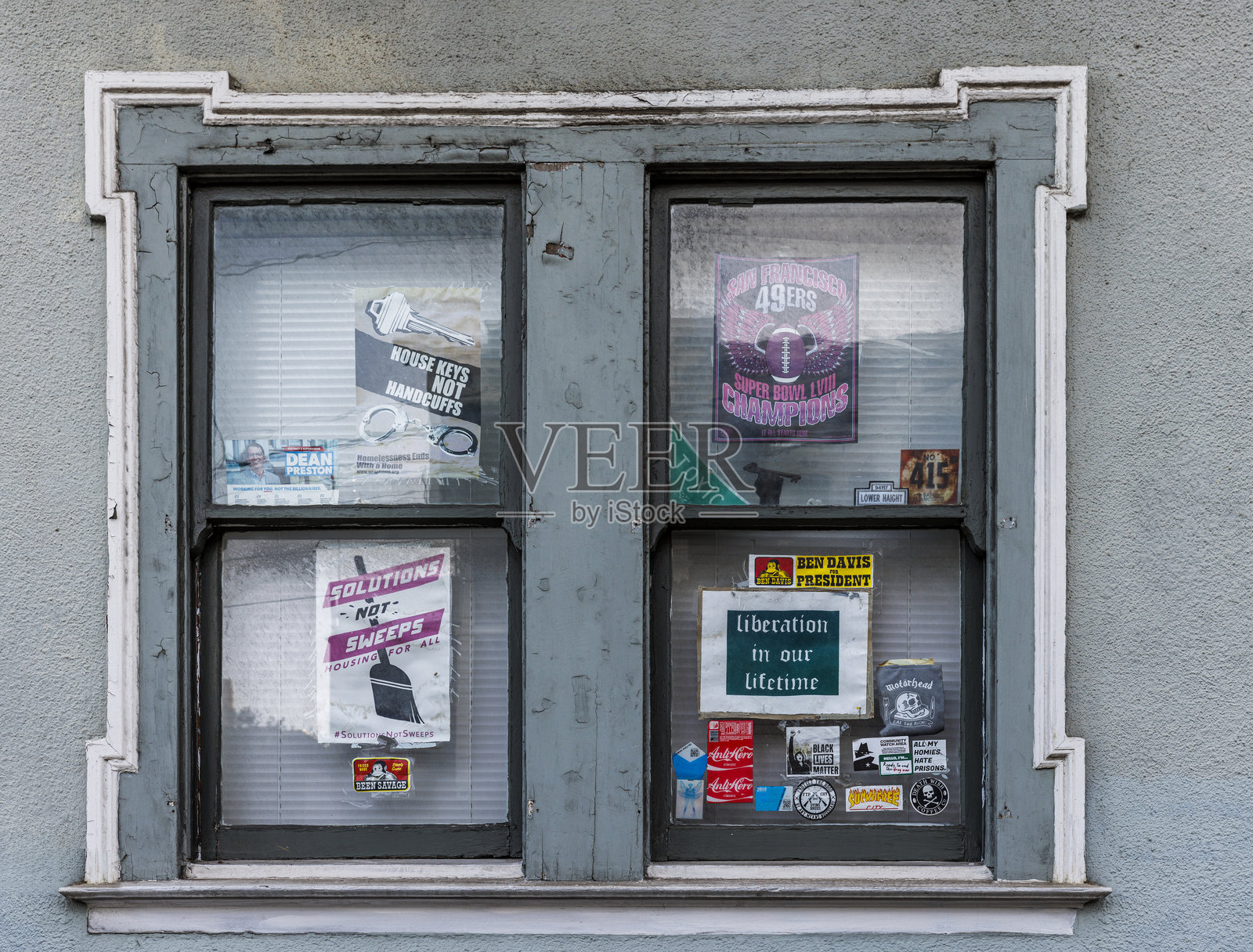旧金山城市旧窗户上的广告拼贴画：风化的外墙展示海报和贴纸照片摄影图片