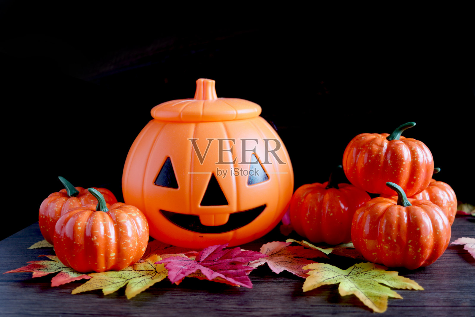万圣节和节日秋季装饰背景，橙色南瓜与木质背景上的叶子。祝您万圣节秋季庆祝愉快。照片摄影图片