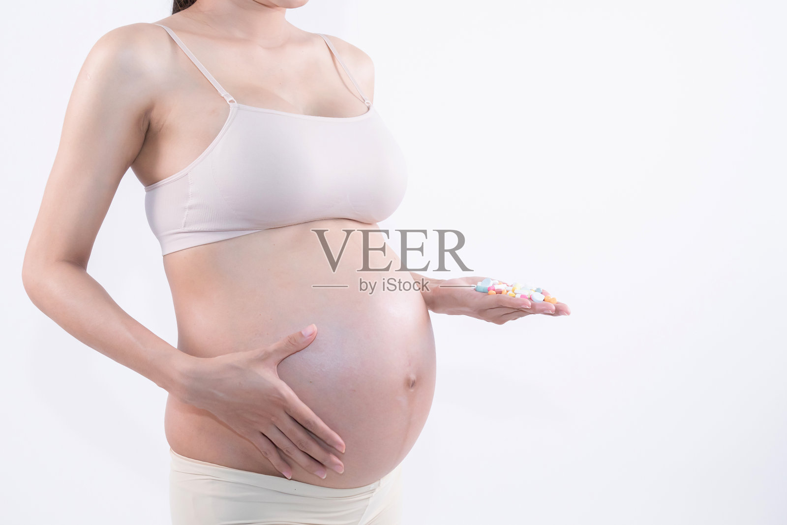 孕妇展示维生素或药物，强调孕期营养与健康照片摄影图片