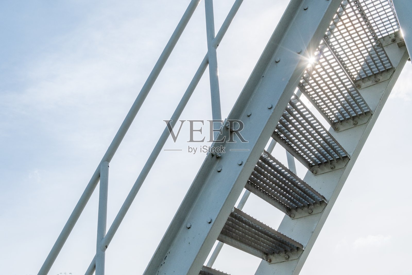 透光的钢制楼梯，台阶由穿孔金属板制成照片摄影图片