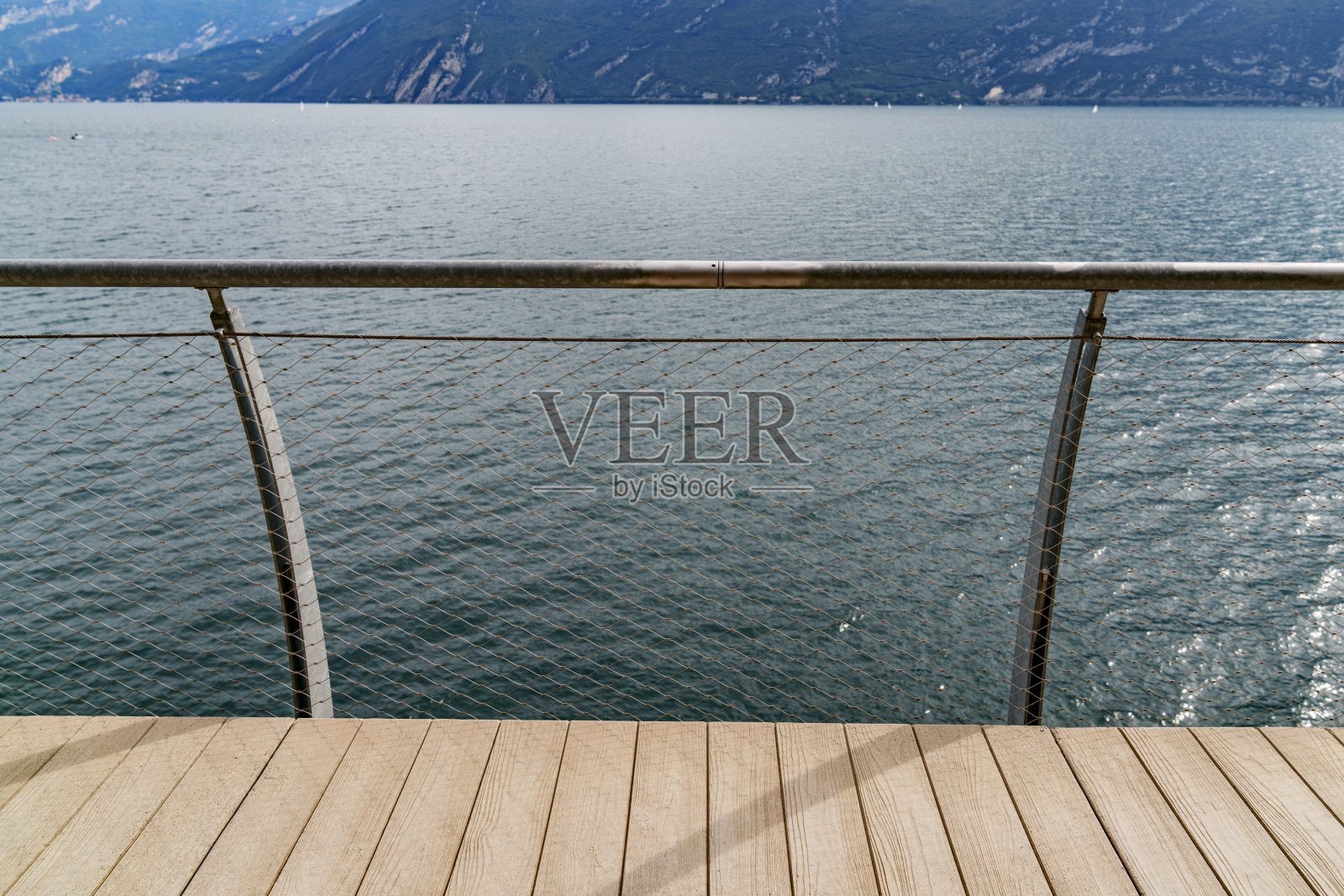 从有金属栏杆的步道上俯瞰山间湖泊的景色。照片摄影图片