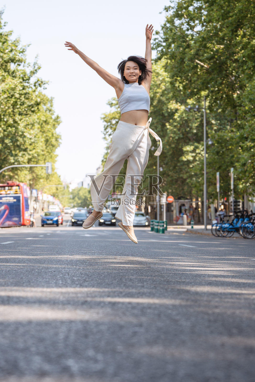 年轻女子在街头喜悦跳跃照片摄影图片
