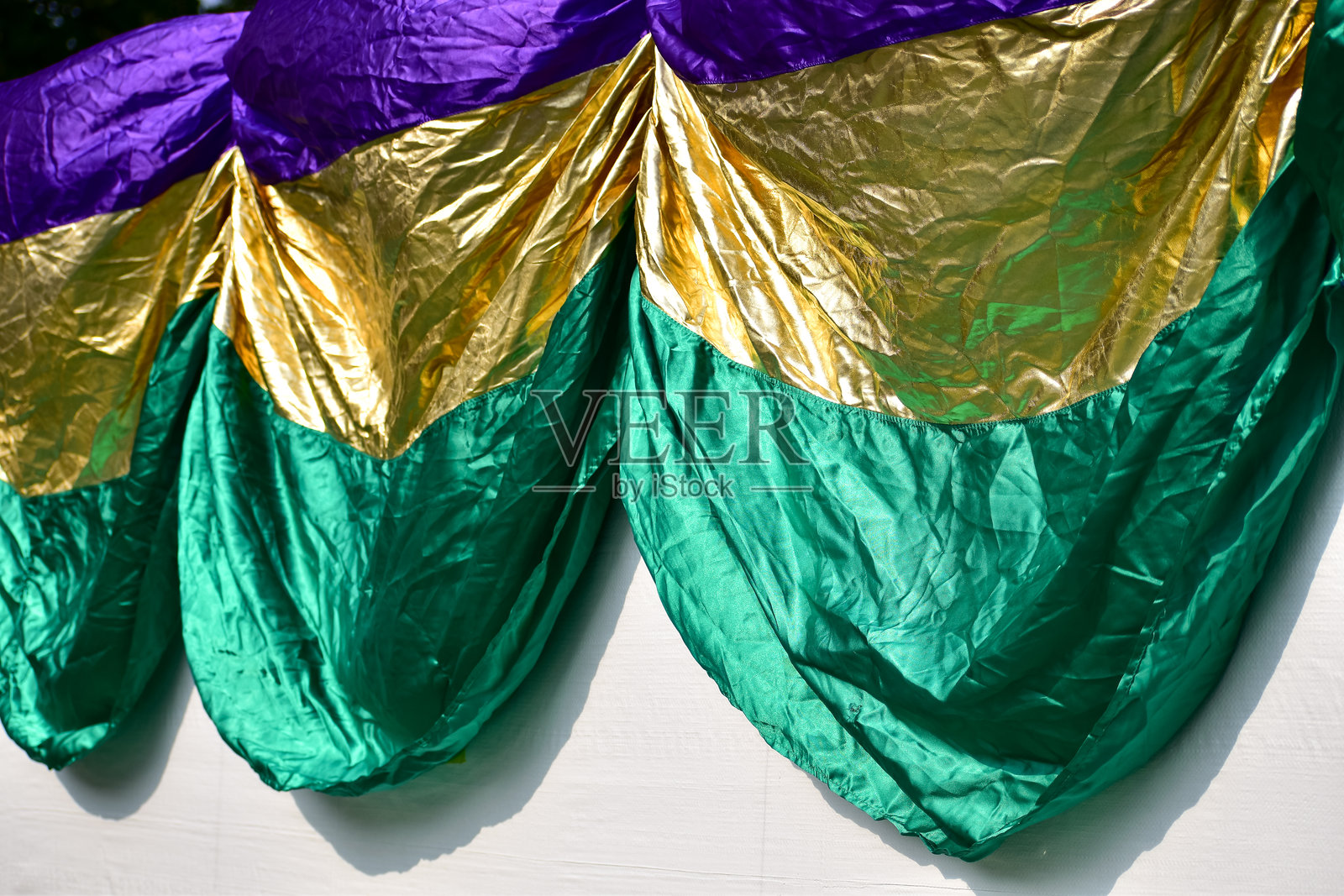 紫色、绿色、金色聚酯材料的狂欢节旗帜特写，布料彩带。用于庆祝和装饰。照片摄影图片