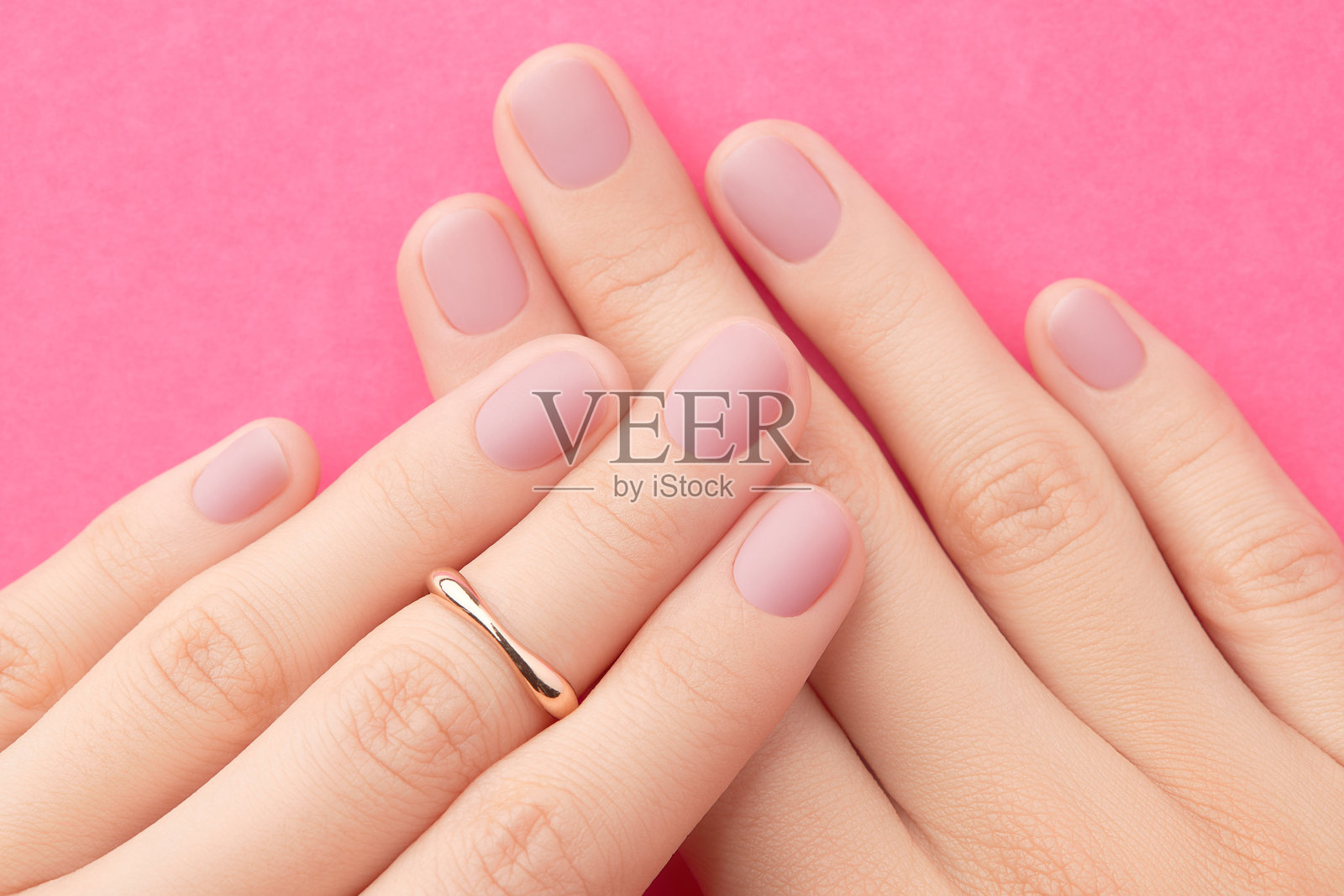 女性手部特写，时尚的粉色哑光美甲。美容院。照片摄影图片