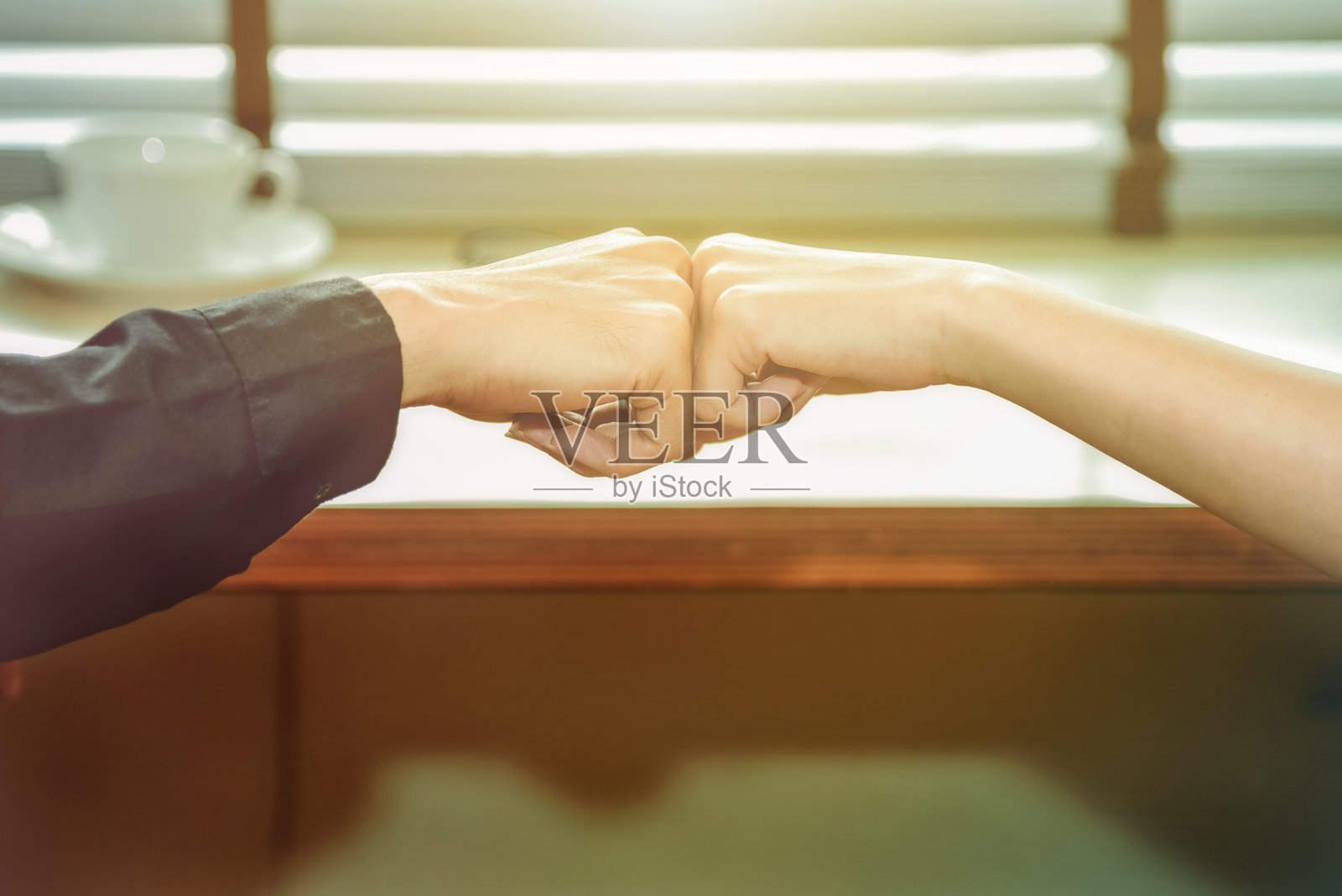 咖啡馆里人们用拳头碰拳头的手部特写照片摄影图片