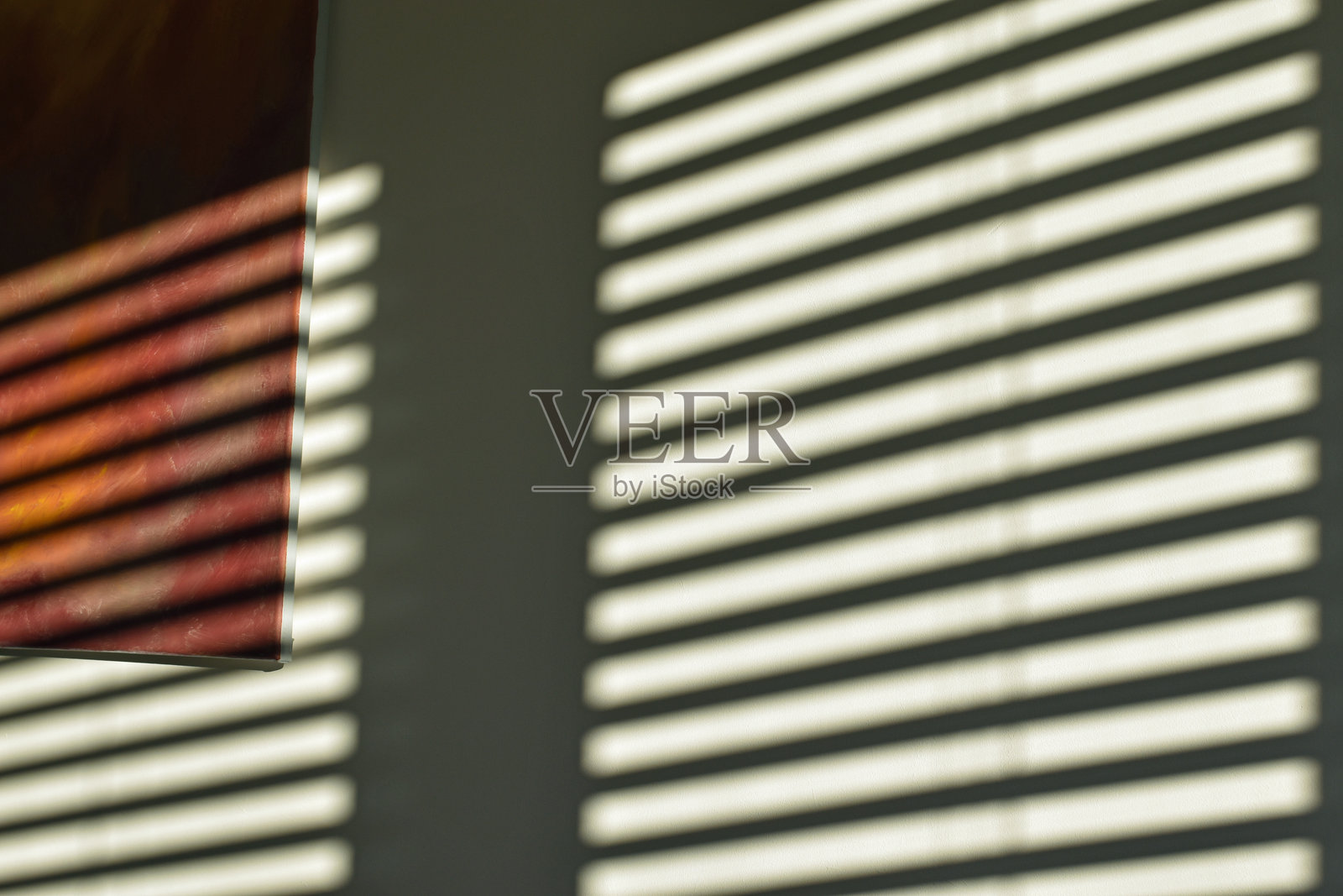 窗帘透出的光线条纹投射在墙上。富有氛围的抽象室内设计照片摄影图片