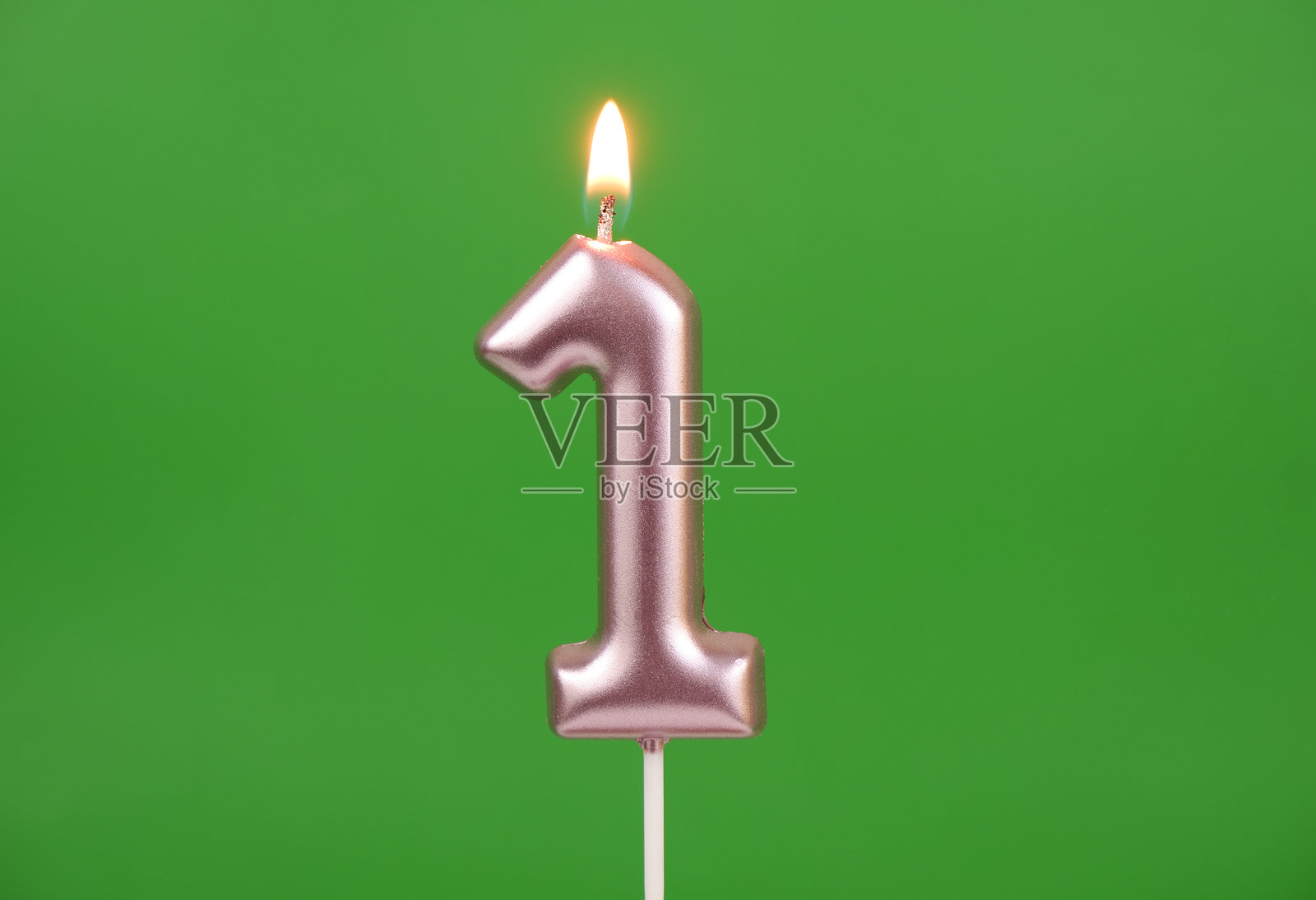 绿色背景上的粉色生日蜡烛，数字1照片摄影图片