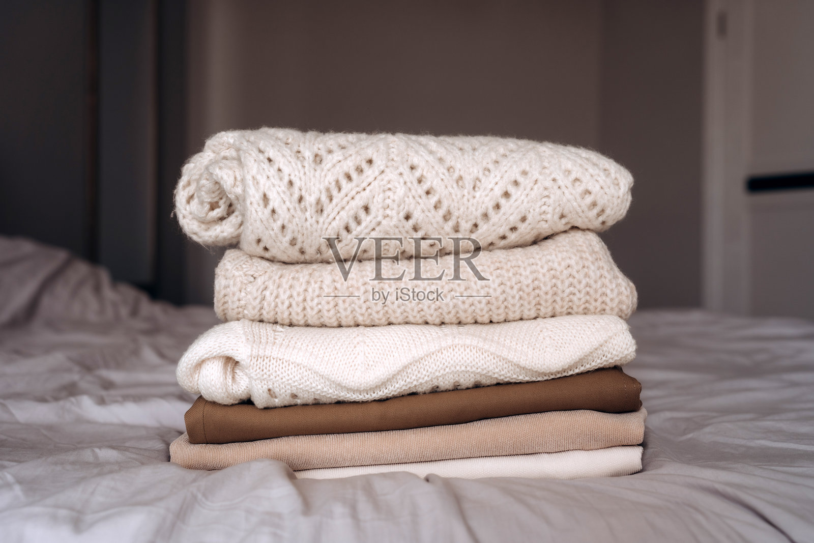 床上折叠的舒适针织毛衣照片摄影图片