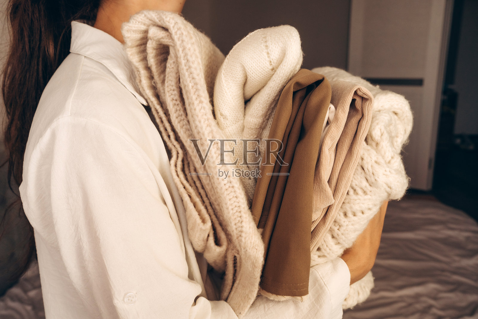 手捧折叠针织毛衣的女人照片摄影图片