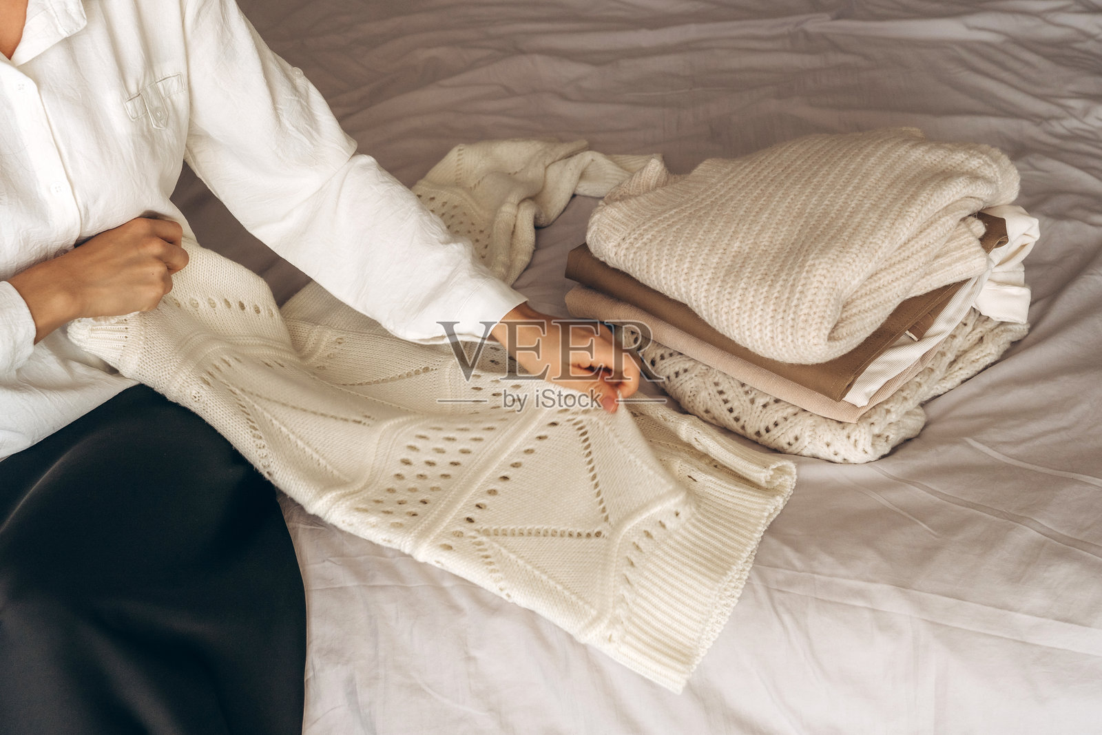 年轻女子在床上整理温暖的针织品照片摄影图片