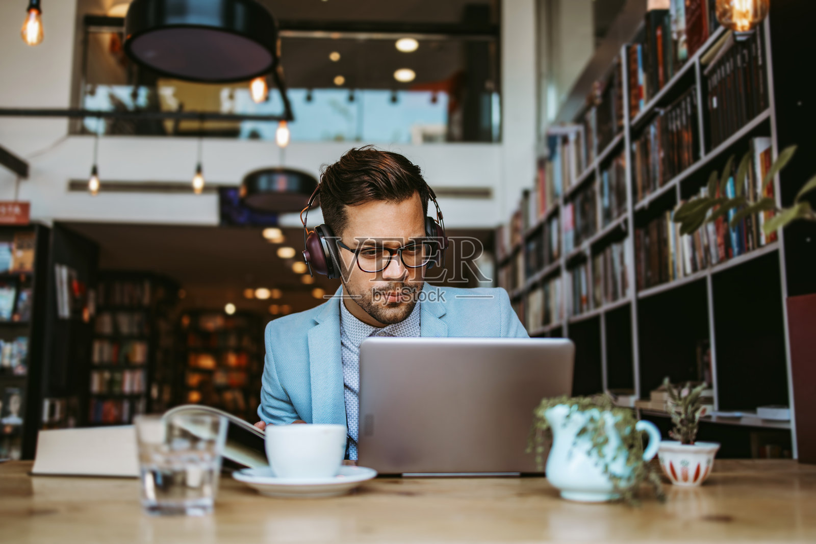 帅气的学生或在图书馆工作的记者照片摄影图片