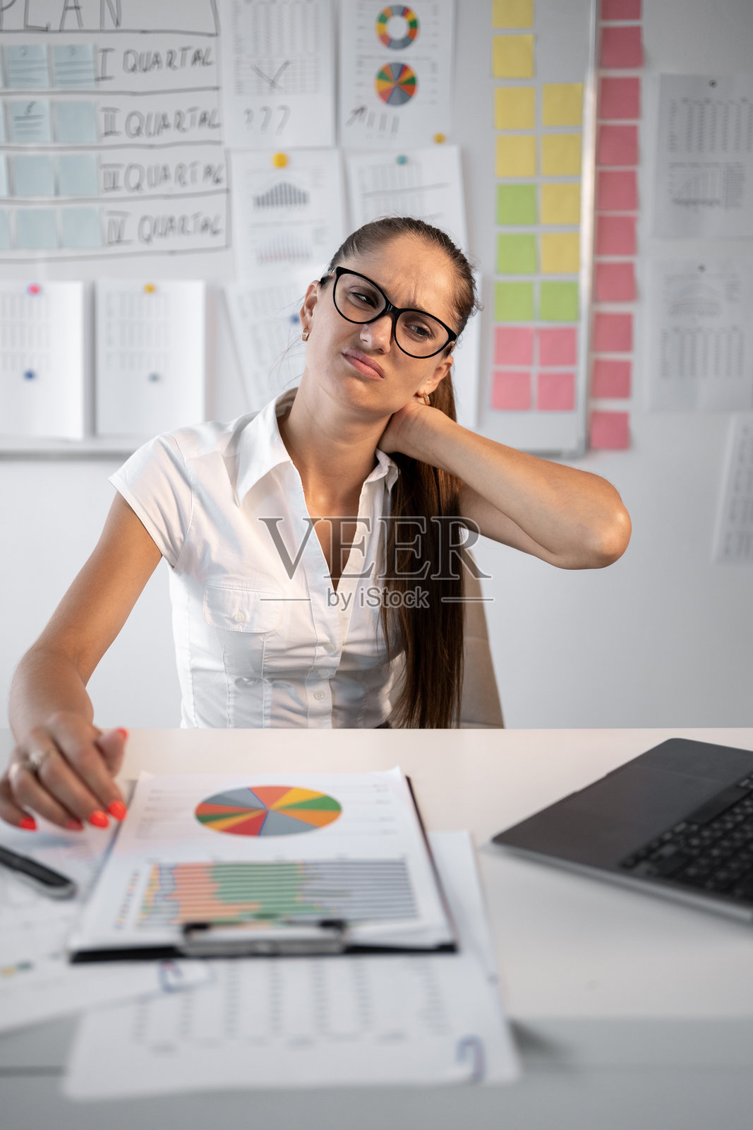 在办公室工作时肌肉酸痛的年轻女商人照片摄影图片