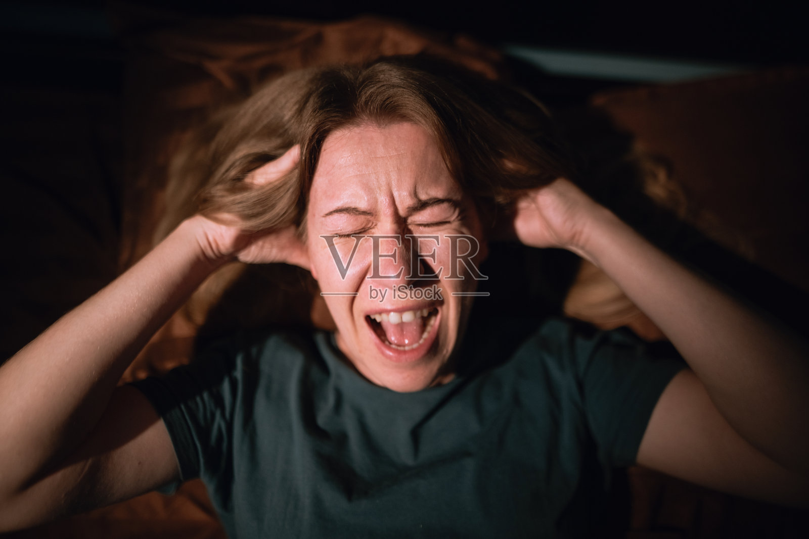 在夜晚感到焦虑并尖叫的女人，有噩梦、睡眠障碍和惊恐发作照片摄影图片