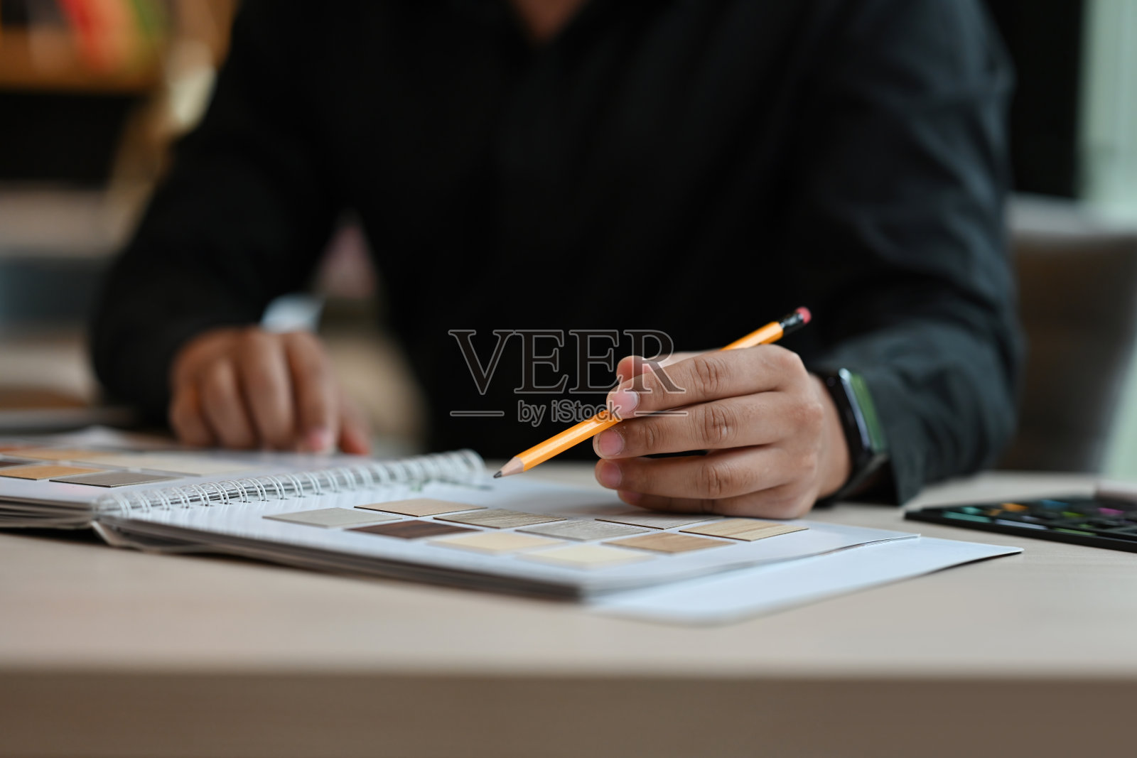 建筑师的手在选择和指向材料样本，设计师正在进行室内建筑和家具设计项目的特写镜头。照片摄影图片