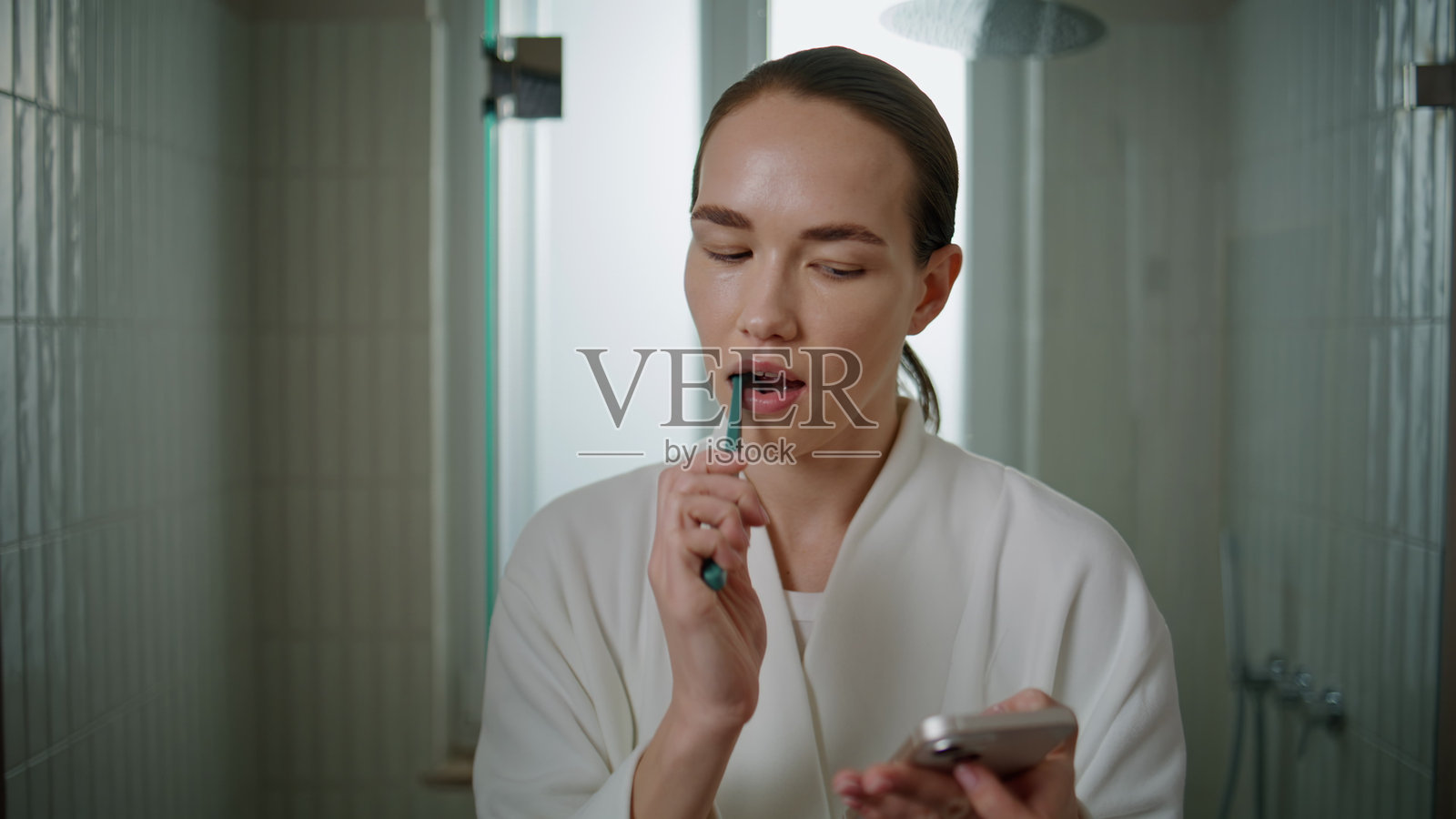 使用智能手机清洁牙齿的模特特写，漂亮的女人在做牙科护理照片摄影图片