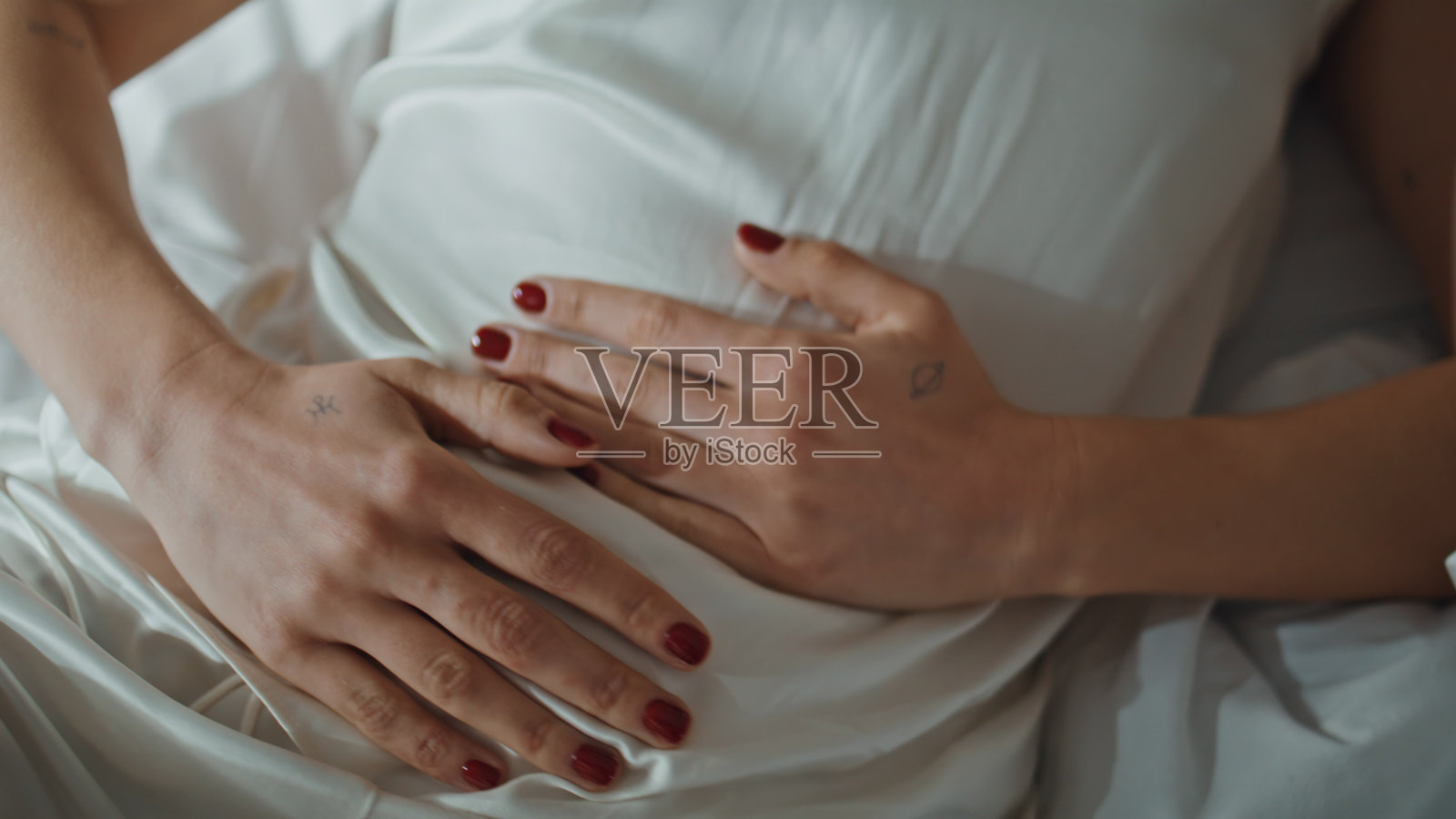 手部按压疼痛的腹部特写，生病女人在家中忍受剧痛照片摄影图片