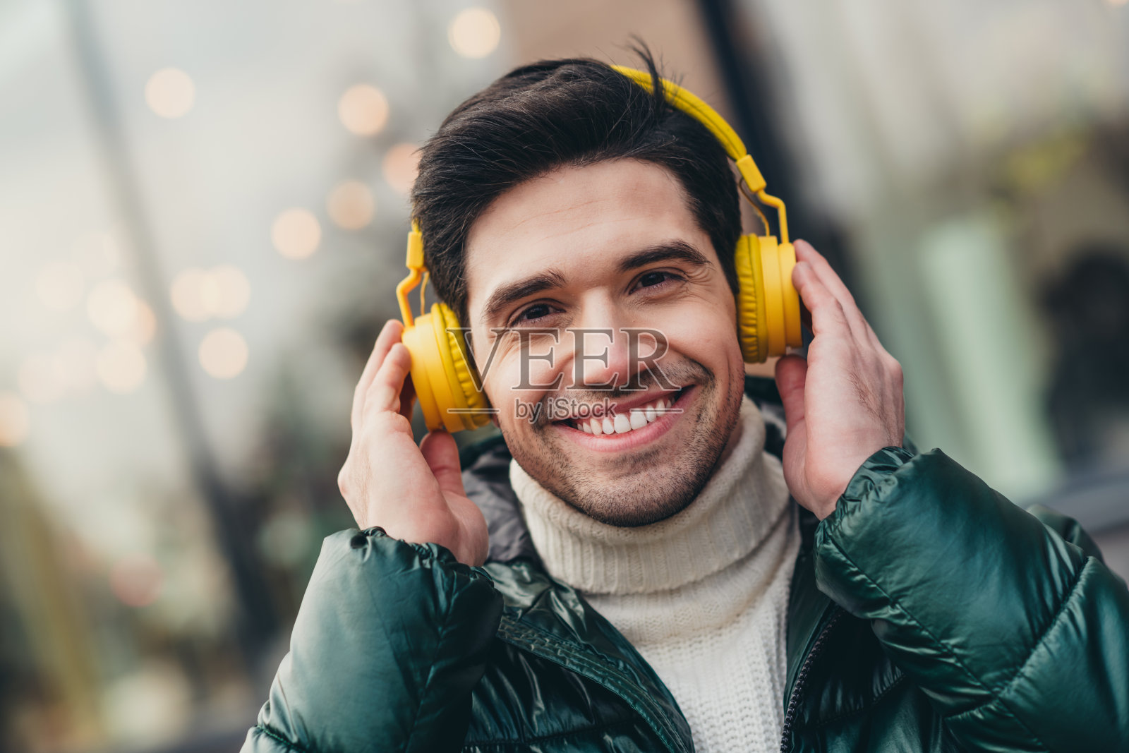 快乐的男士在秋天寒冷的户外城市中边走边听音乐照片摄影图片