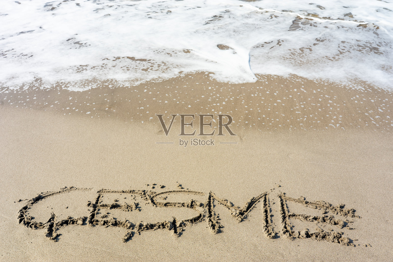 海浪冲刷沙滩上的“切什梅”字样照片摄影图片