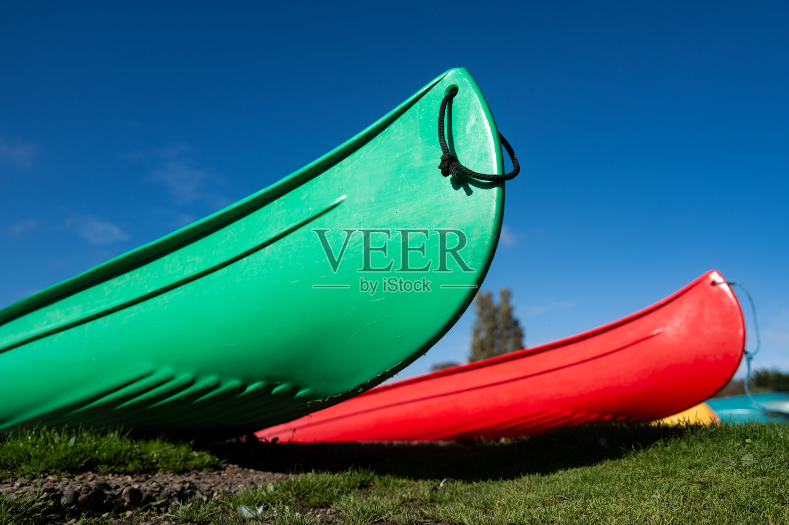 聚焦于湖岸边的绿色皮划艇。照片摄影图片