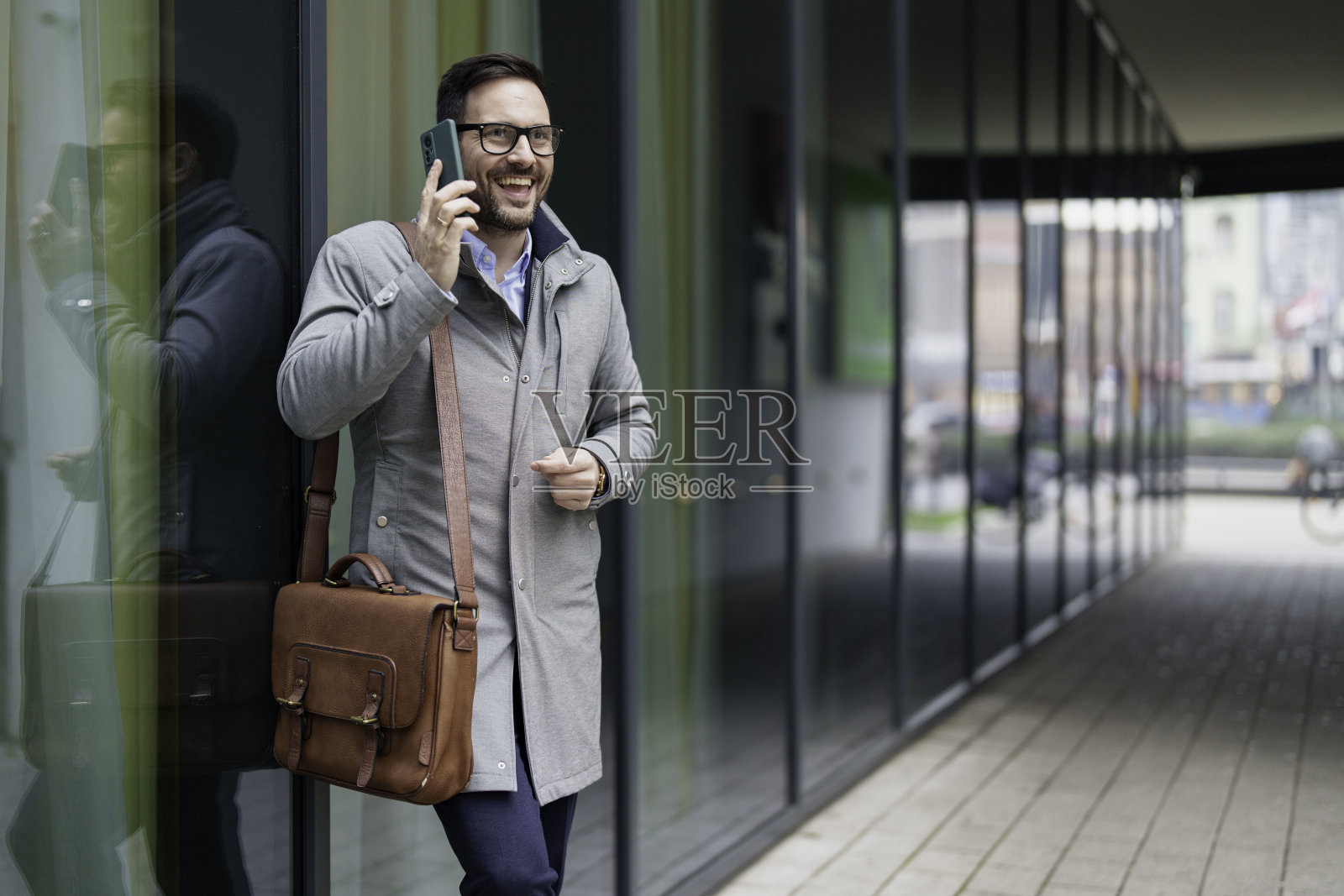 在户外进行手机交谈的商务人士照片摄影图片