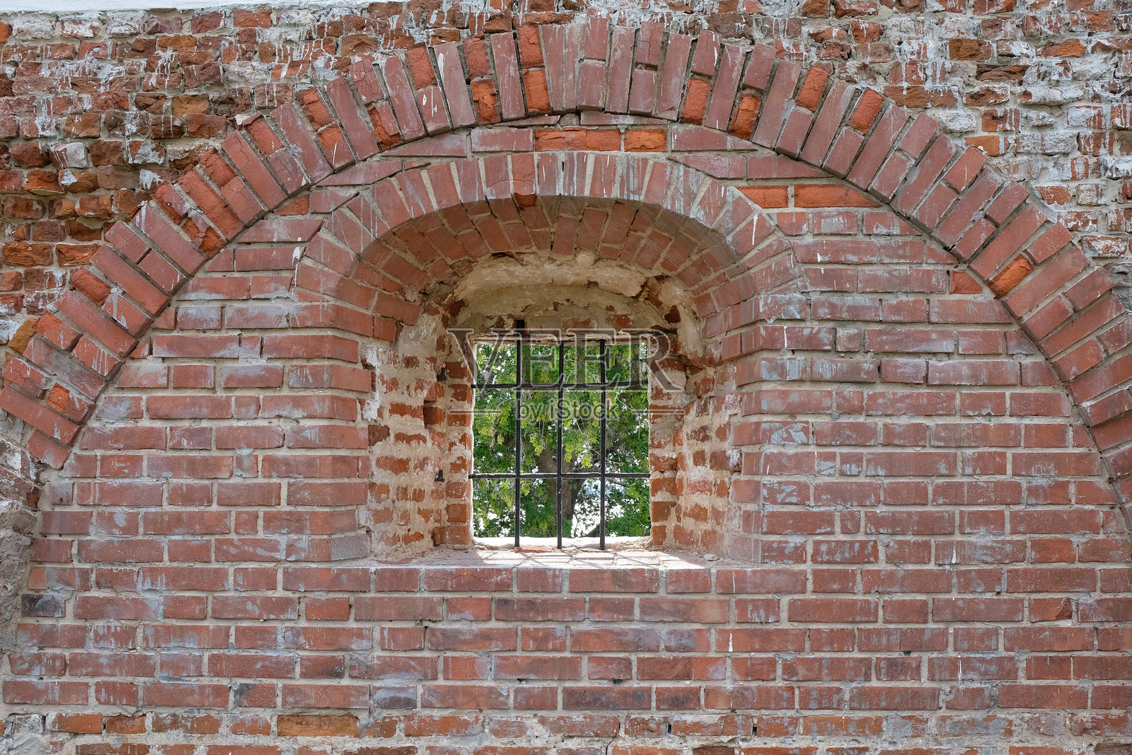 古老砖砌堡垒的碎片，带金属栏杆的窗户，从内部视角看照片摄影图片