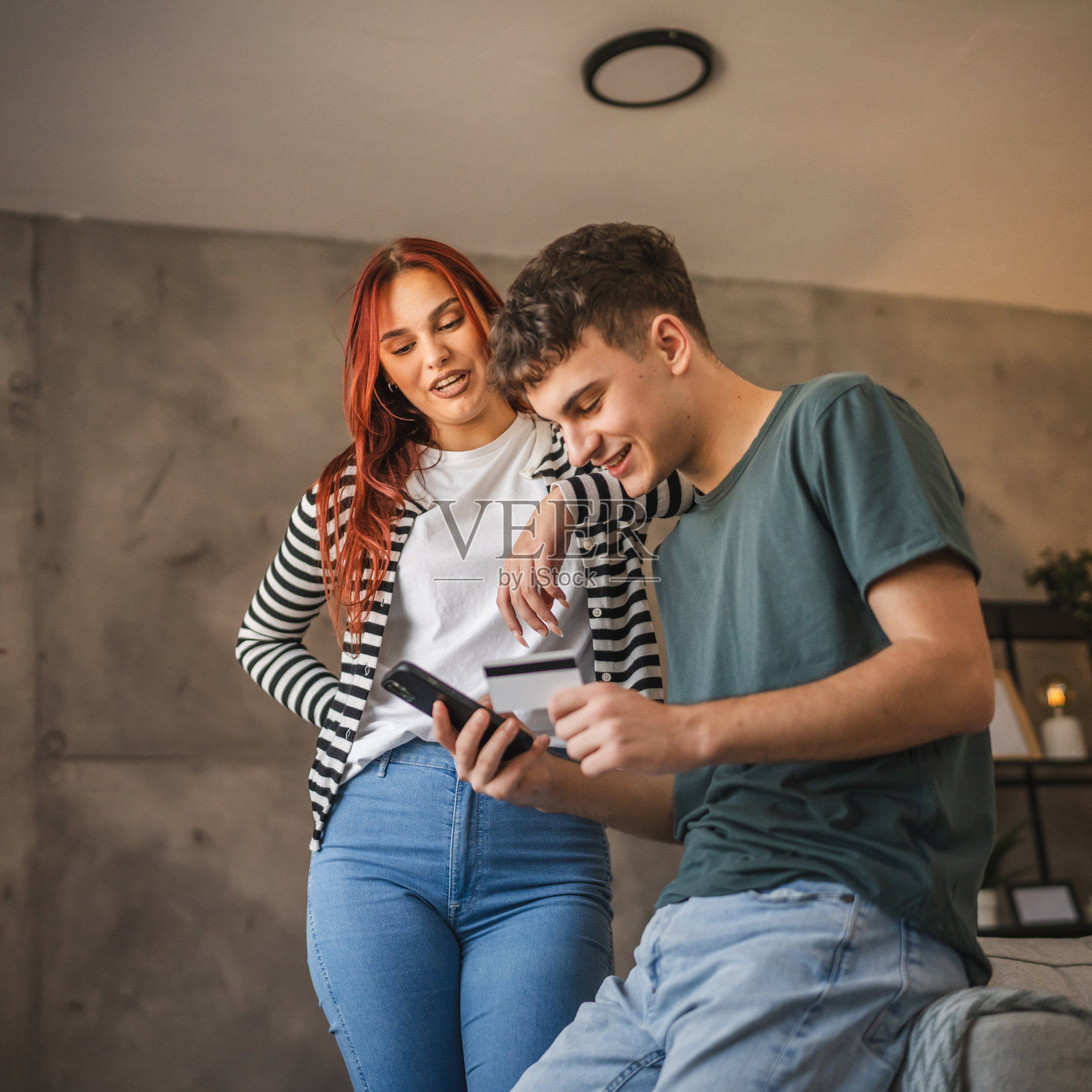 快乐的年轻夫妇在家用手机信用卡在线购物照片摄影图片