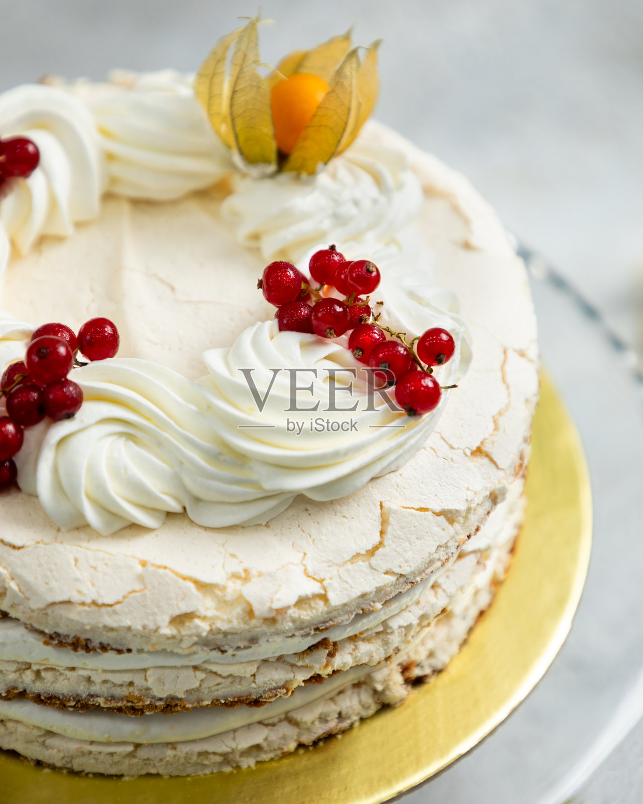 美味的蛋白霜蛋糕，上面装饰着红醋栗和灯笼果照片摄影图片