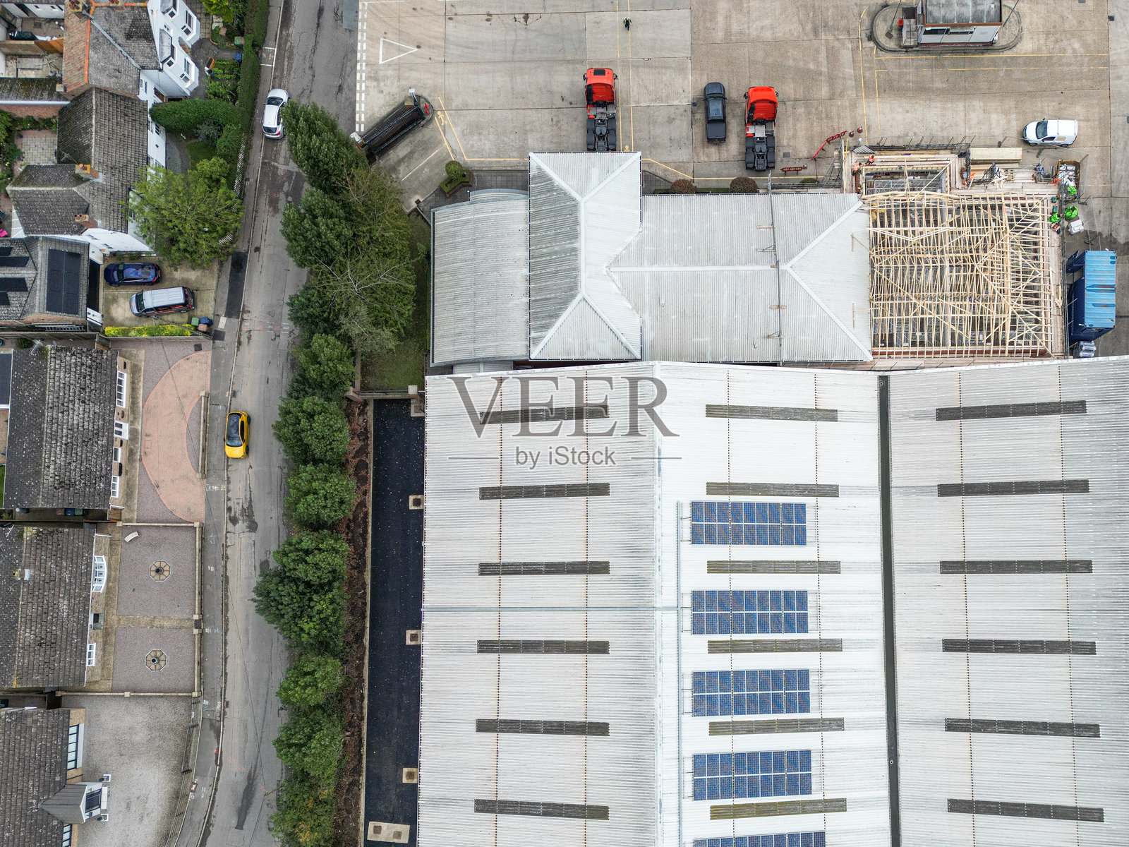 无人机视角：大型配送仓库，正面停有多辆卡车和拖车照片摄影图片