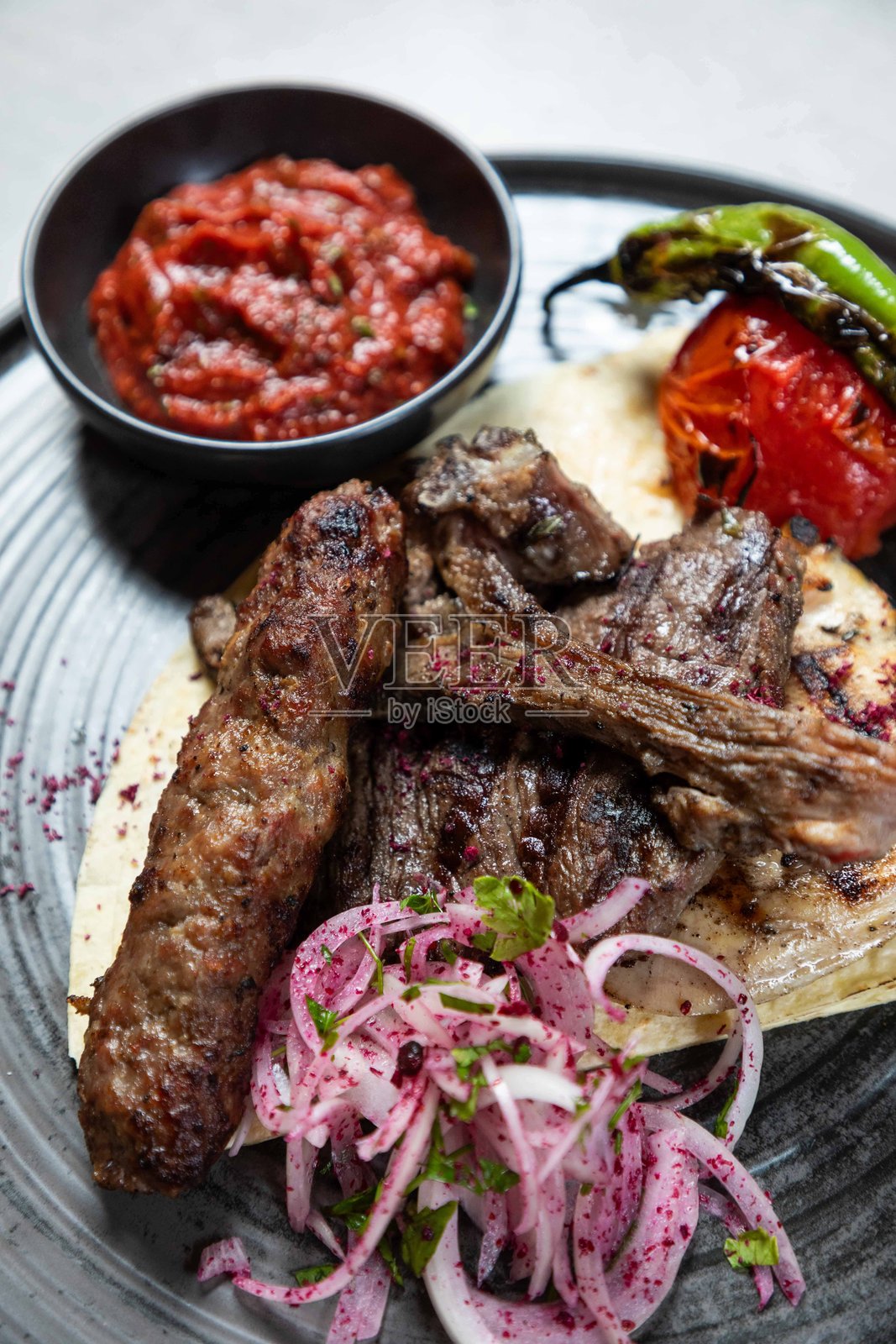 烤羊肉和牛肉串配腌制洋葱和辣酱照片摄影图片