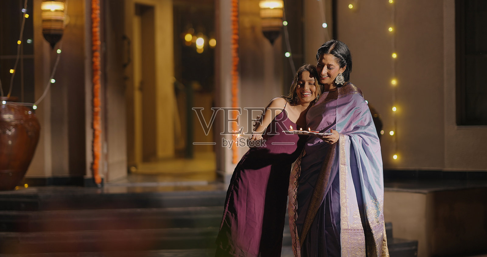 印度教家庭在传统服饰中燃放鞭炮庆祝排灯节，户外家居装饰照片摄影图片