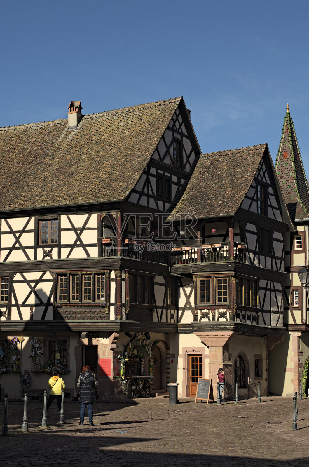 古老住宅之间的风景石板街。中世纪村庄里克维尔的传统街道。它位于葡萄酒之路上。照片摄影图片