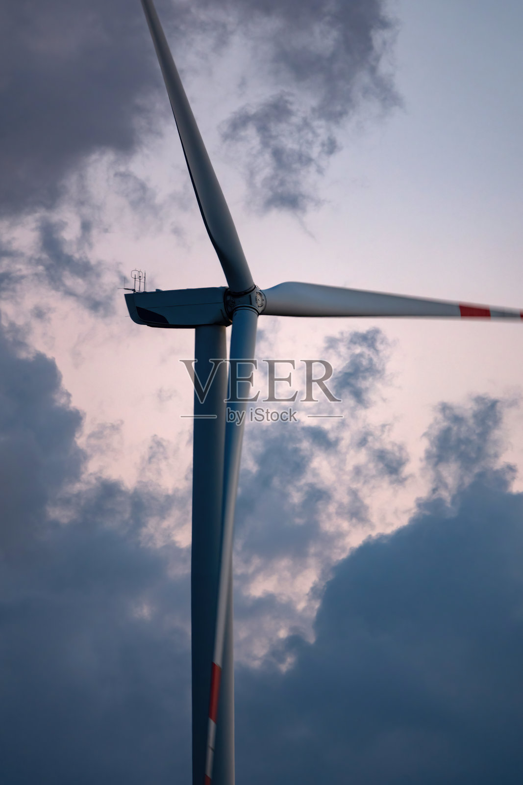 云雾弥漫的日落时分的风力涡轮机。照片摄影图片