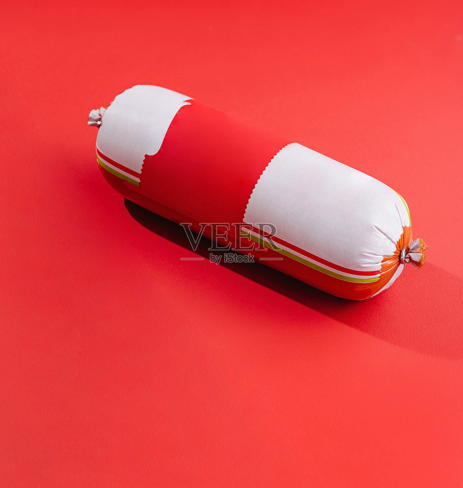 香肠躺在鲜艳的红色背景上照片摄影图片