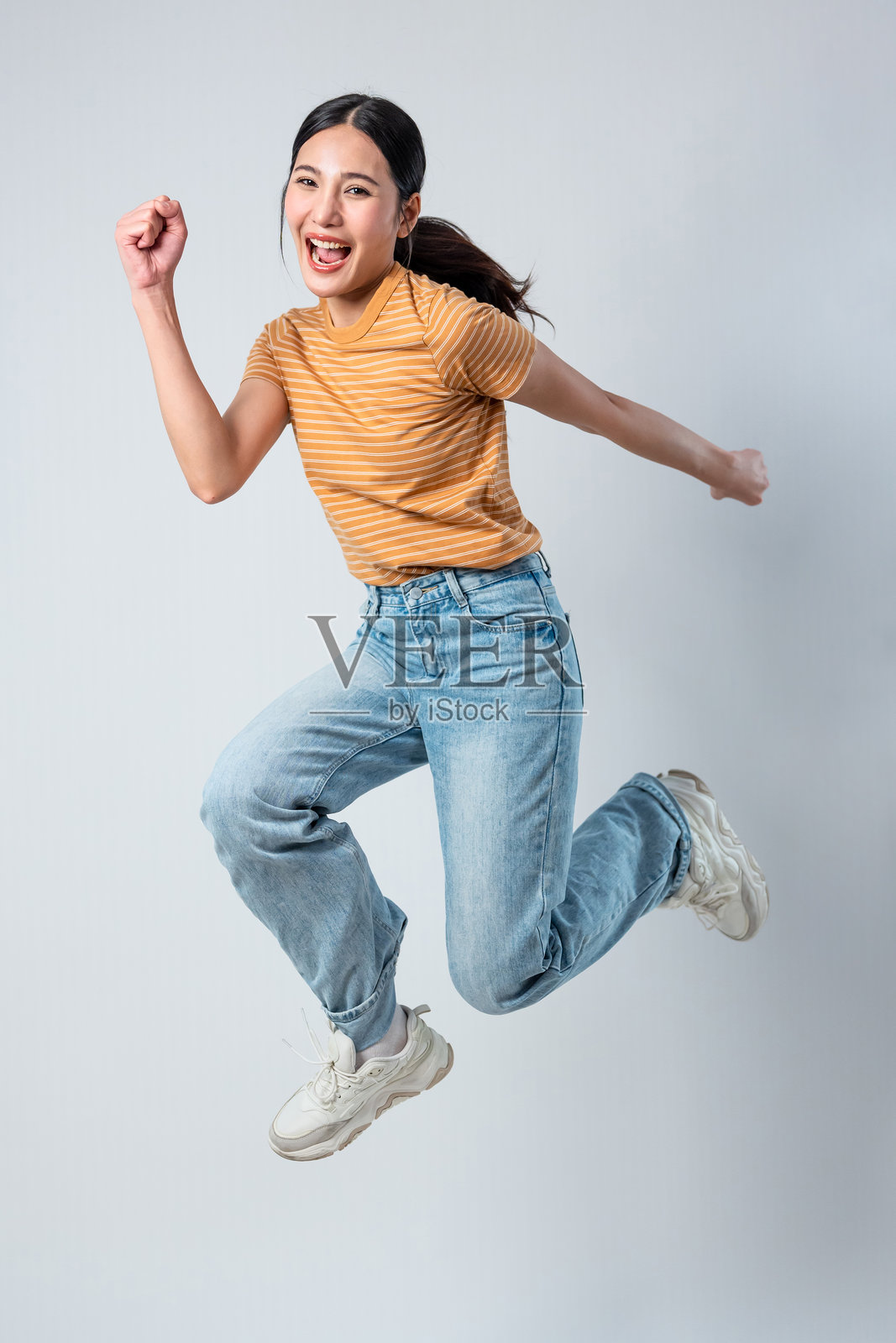 在灰色背景中跳跃的亚洲女性照片摄影图片